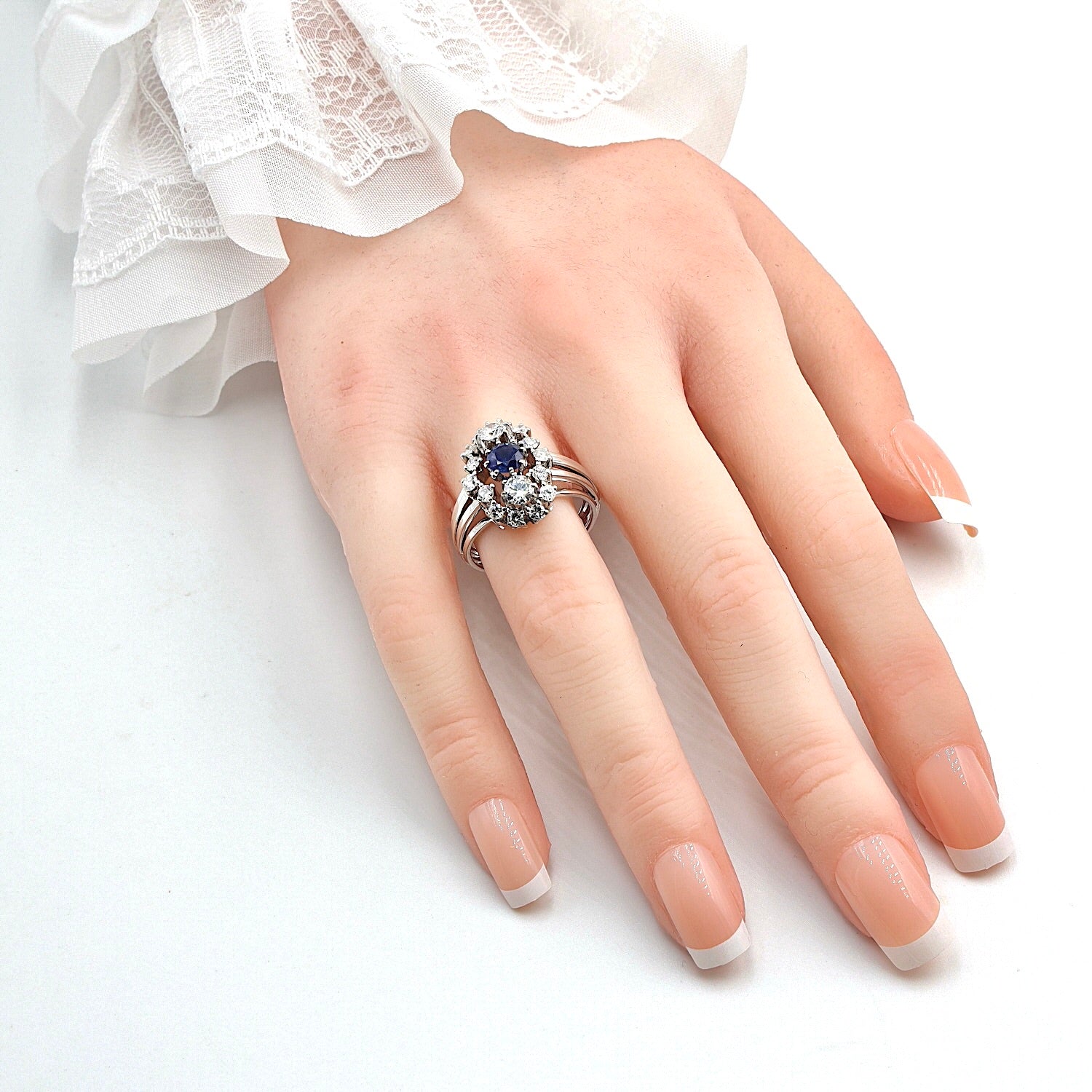 Vintage Ring in 590er Weißgold mit einem Saphir und insgesamt ca. 1,25 ct Brillanten, an der Hand