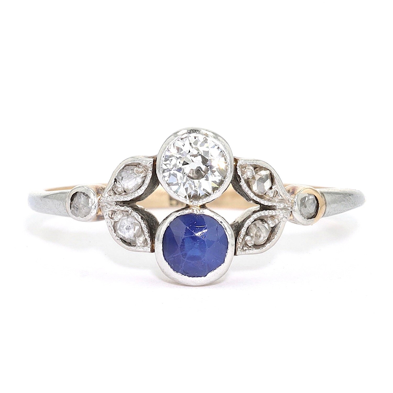 Antiker Ring um 1910 in 585er Gelbgold platiniert mit Diamanten und einem Saphir, liegend frontal