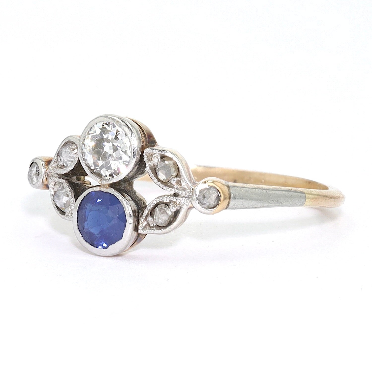 Antiker Ring um 1910 in 585er Gelbgold platiniert mit Diamanten und einem Saphir, liegend links gedreht