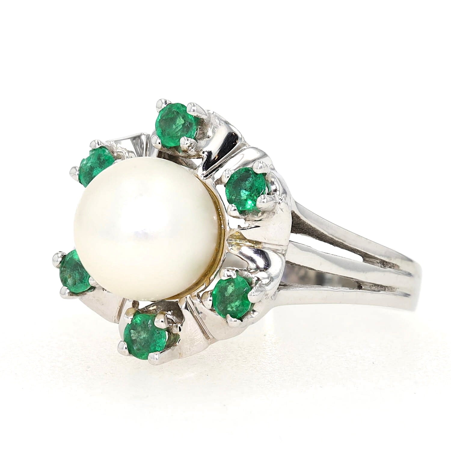 Ring in 585er Weißgold mit einer Akoya-Zuchtperle und Smaragden, liegend links gedreht