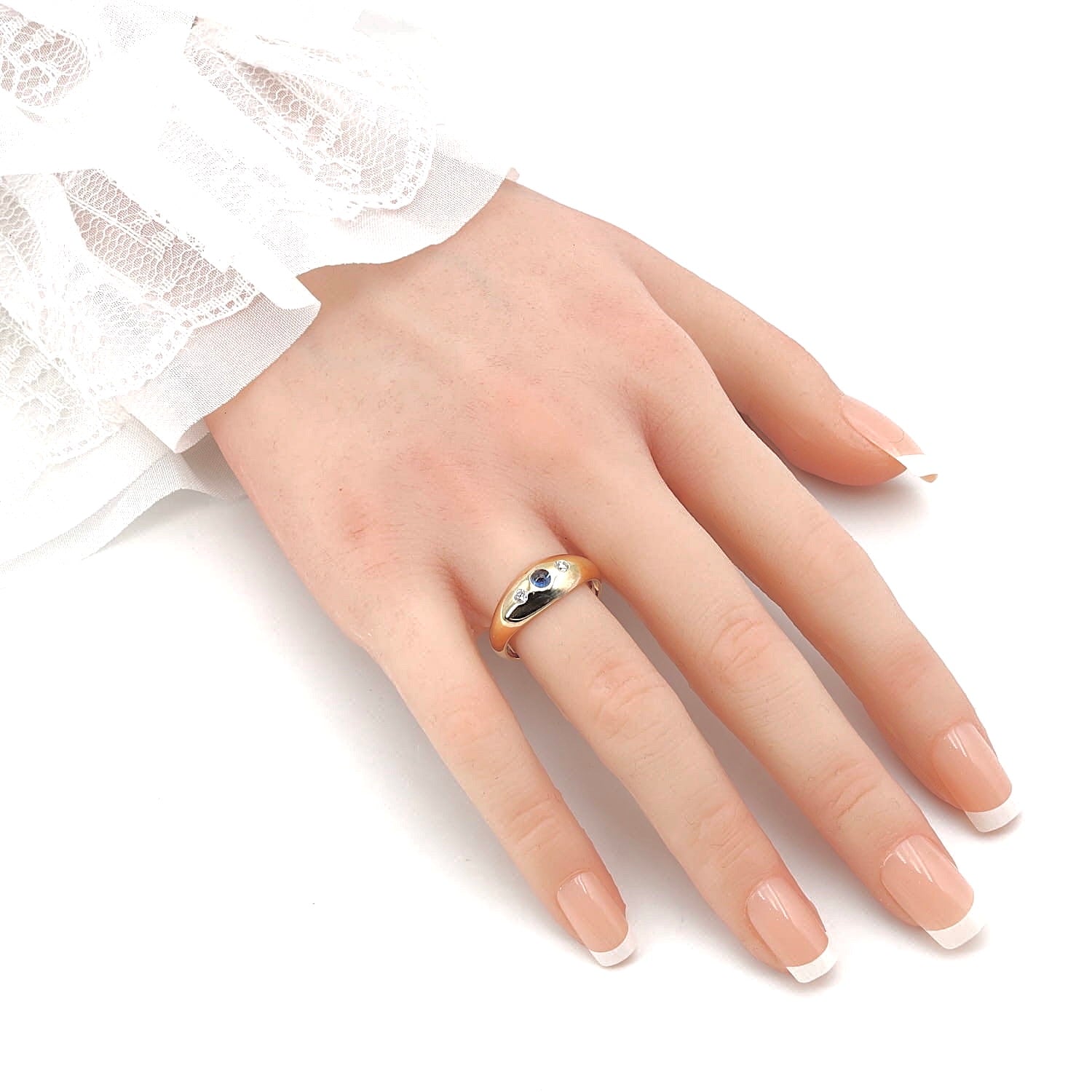 Ring 585er Gelb-Rotgold mit einem blauen Saphir-Cabochon und zwei Brillanten, an der Hand