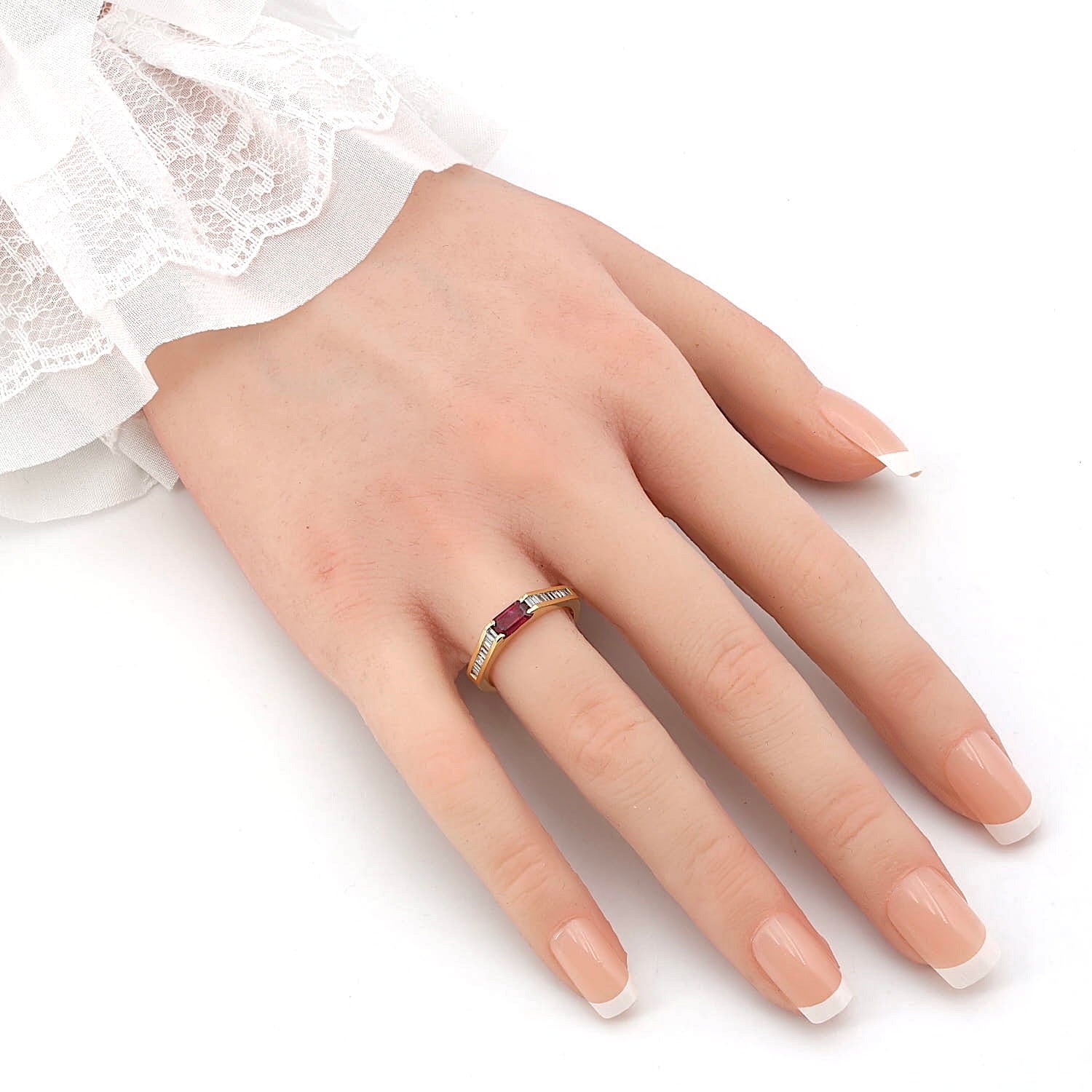 Ring in 750er Gelbgold mit einem Rubin und Diamanten, an einer künstlichen Hand