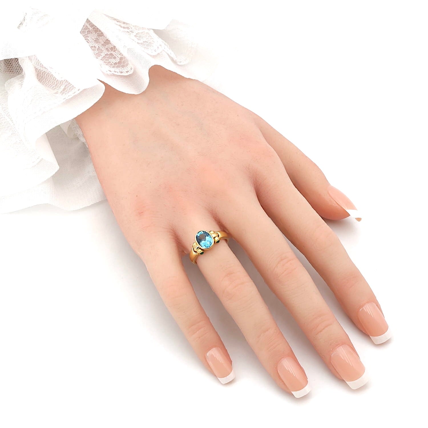 Ring in 750er Gelbgold mit einem blauen Topas und Smaragden, an der Hand