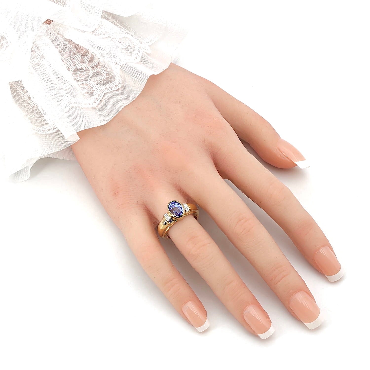 Ring in 750er Gelbgold mit einem blauen Saphir und Diamanten, an der Hand