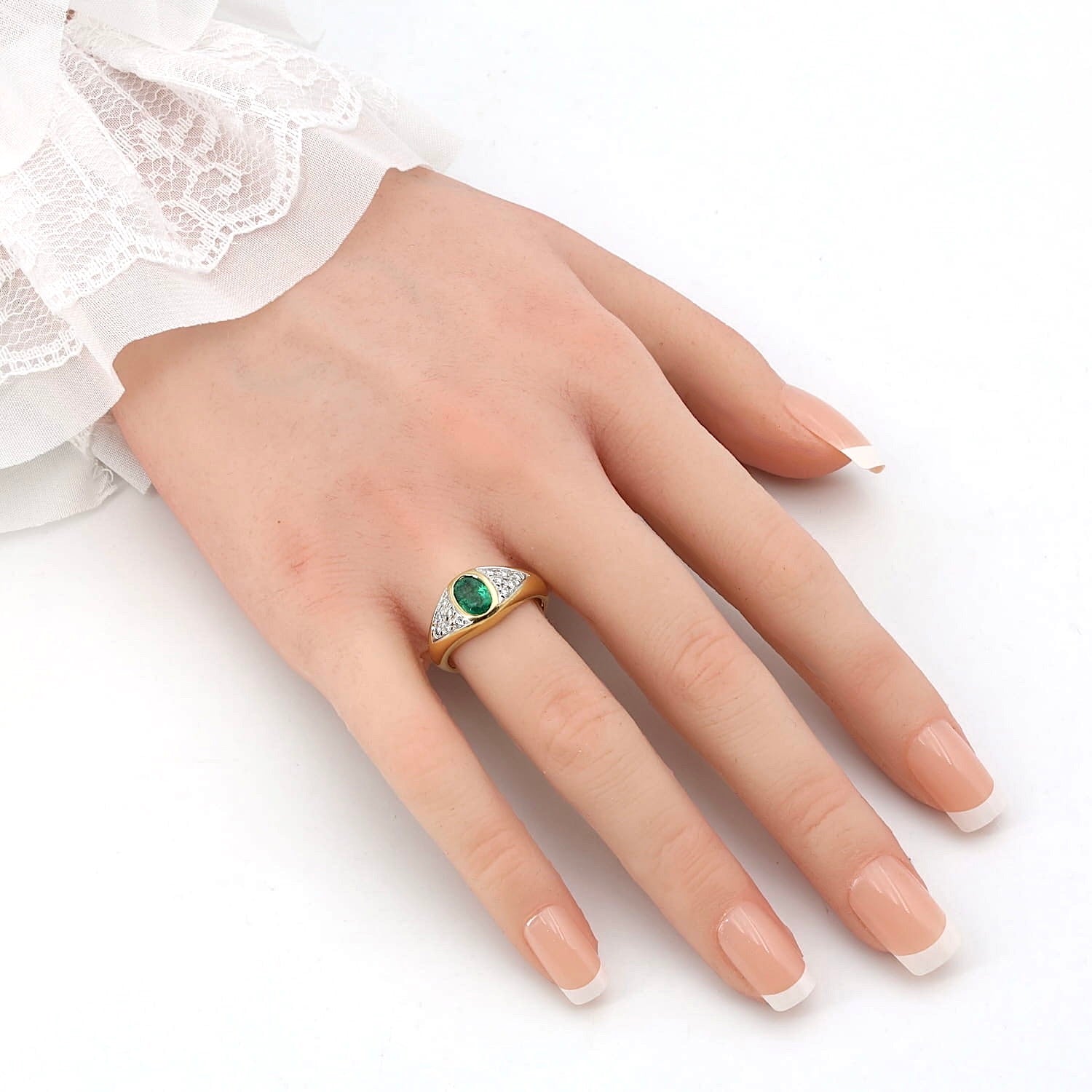 Ring in 750er Gelbgold mit einem Smaragd und Brillanten, an der künstlichen Hand