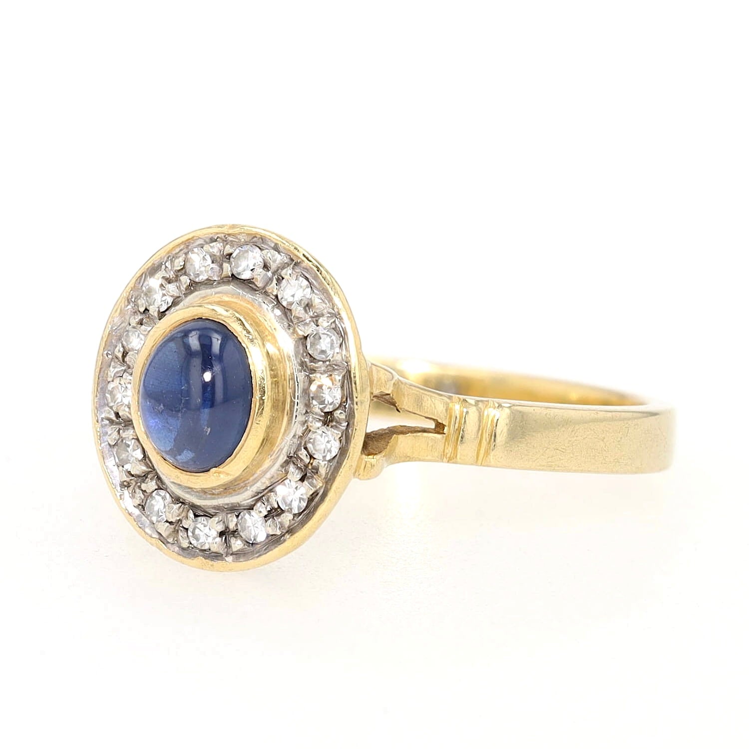 Ring in 750er Gelbgold mit einem blauen Saphir-Cabochon und Diamanten, liegend links gedreht