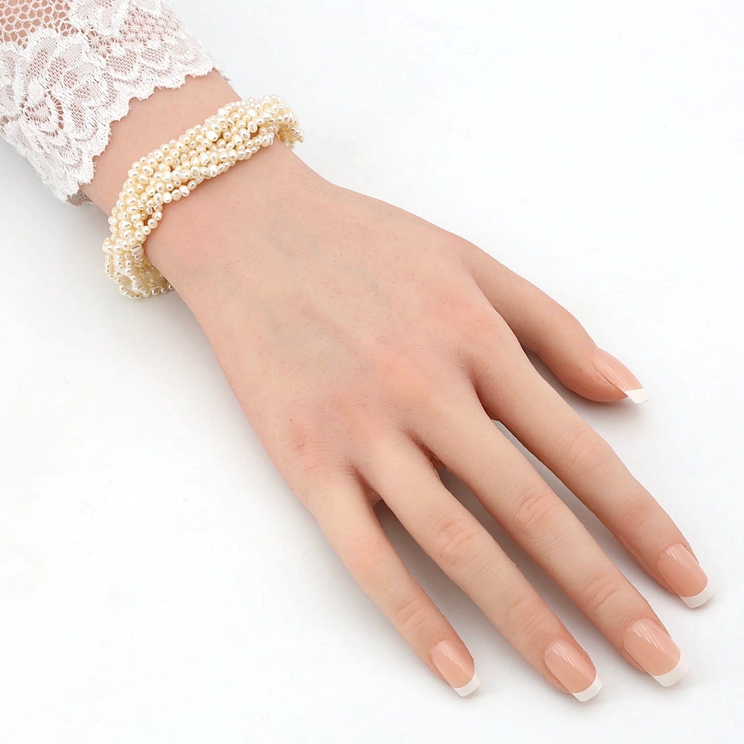 Armband mit 8 in einander gedrehter Reihen Zuchtperlen und einem Schloss aus Silber, am Arm