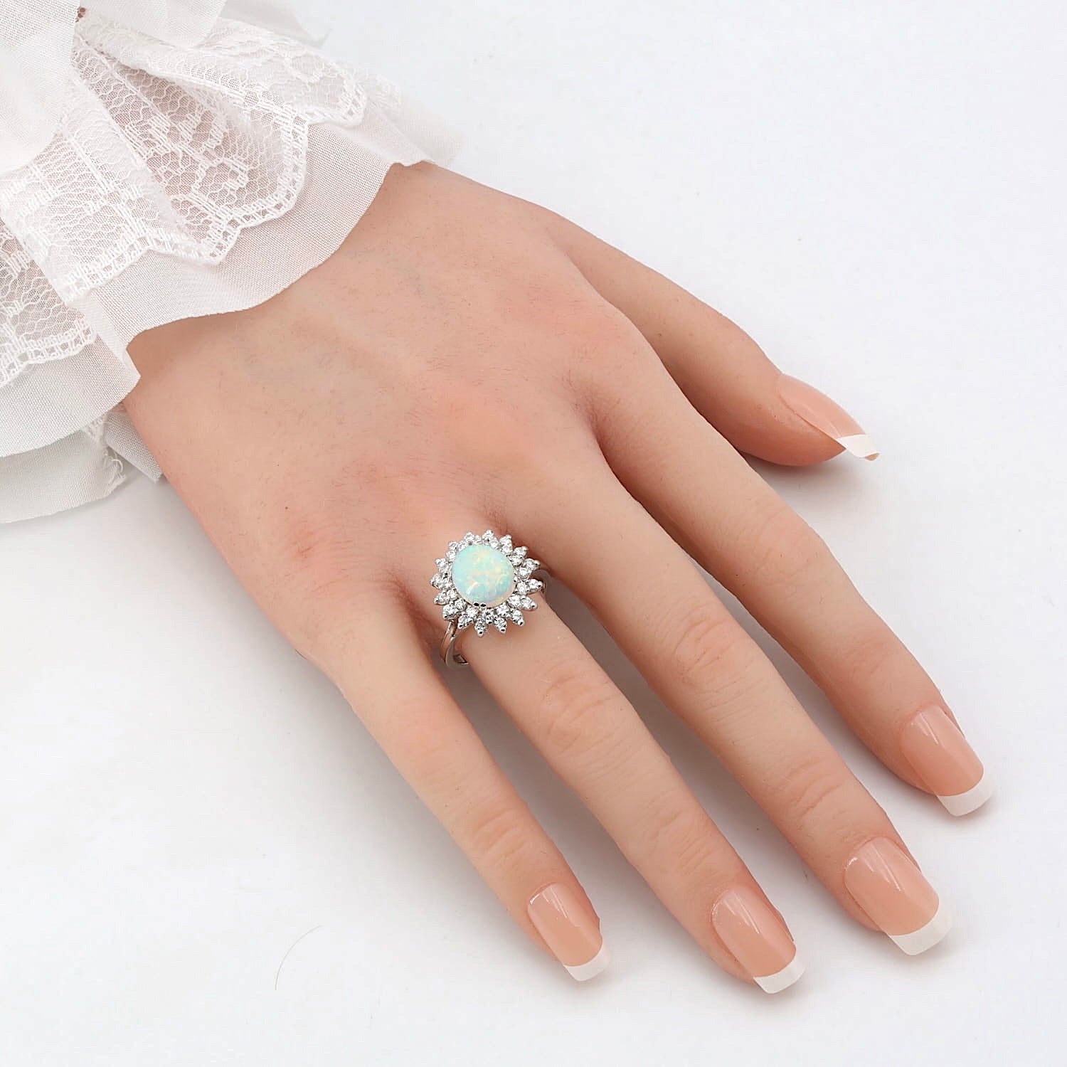 Ring in 750er Weißgold mit einem Opal und insgesamt ca. 0,80 ct Brillanten, an einer künstlichen Hand