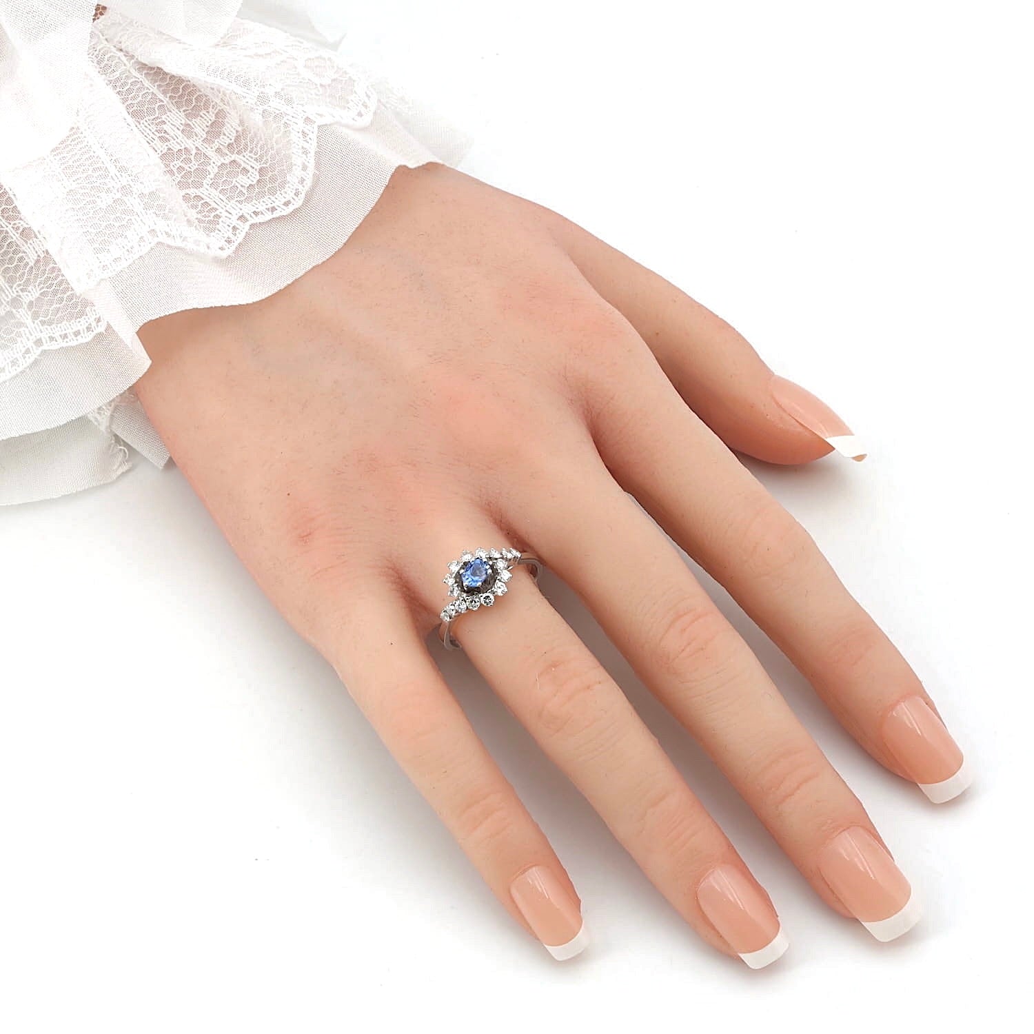 Ring in 585er Weißgold mit einem Saphir und Brillanten, an einer künstlichen Hand