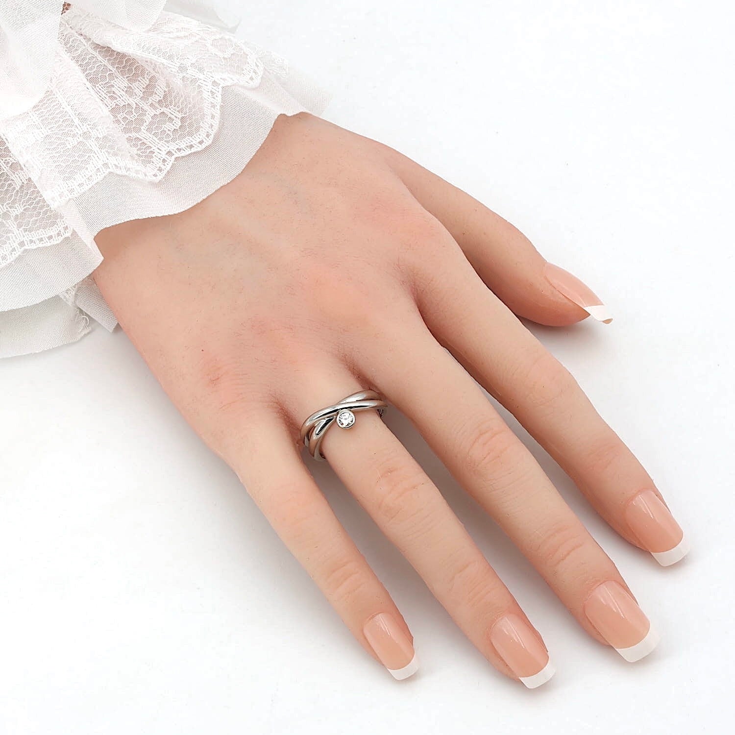 Ring in 585er Weißgold mit einem Brillanten, an einer künstlichen Hand