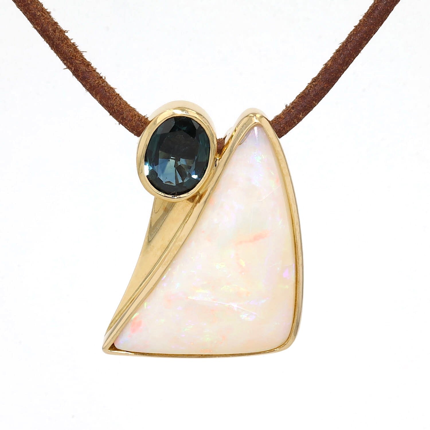 Anhänger in 750er Gelbgold mit einem Opal und einem blauen Saphir, hängend frontal an einem braunen Lederband