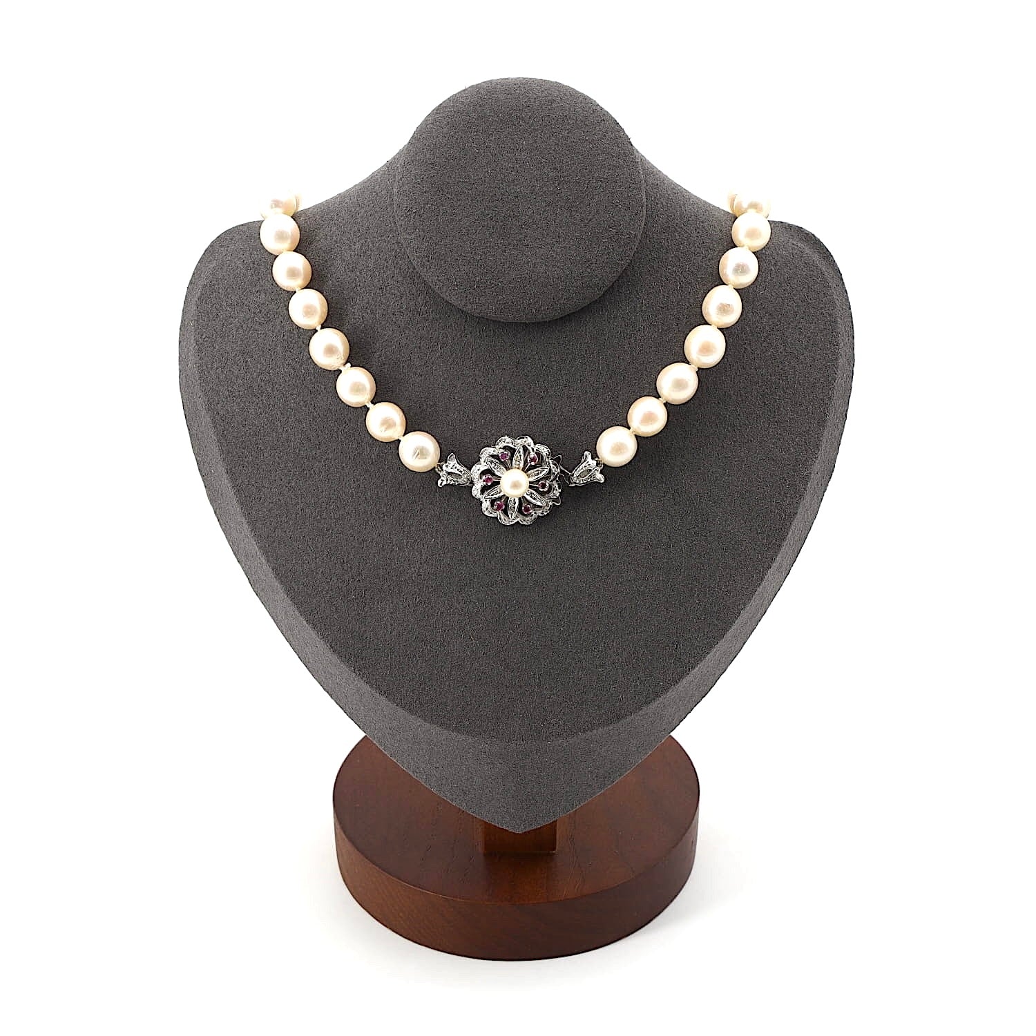 Akoya-Zuchtperlenkette mit einem 750er Weißgoldschloß mit Zuchtperle und Rubinen, an einer dunklen Büste
