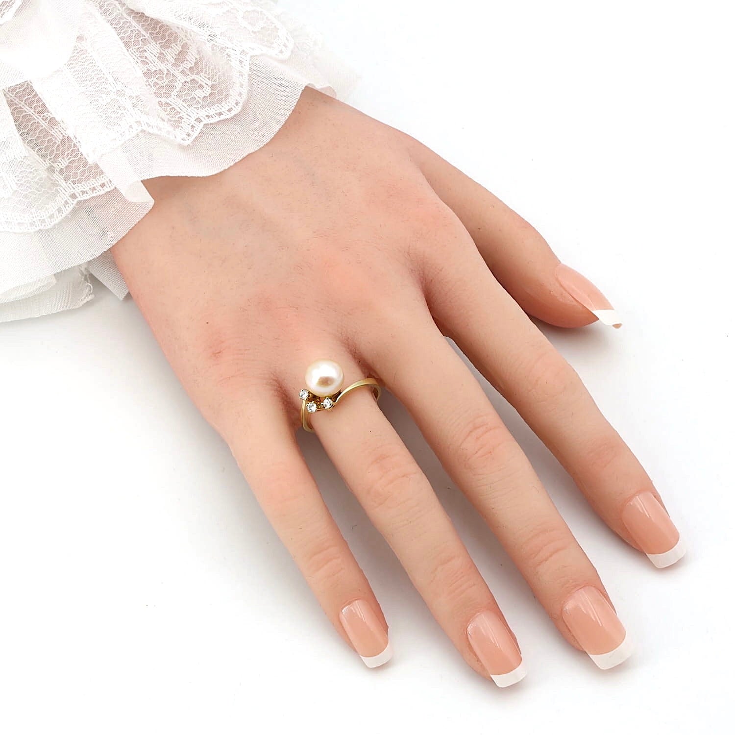 Ring in 585er Gelbgold mit einer Zuchtperle und Brillanten, an einer künstlichen Hand