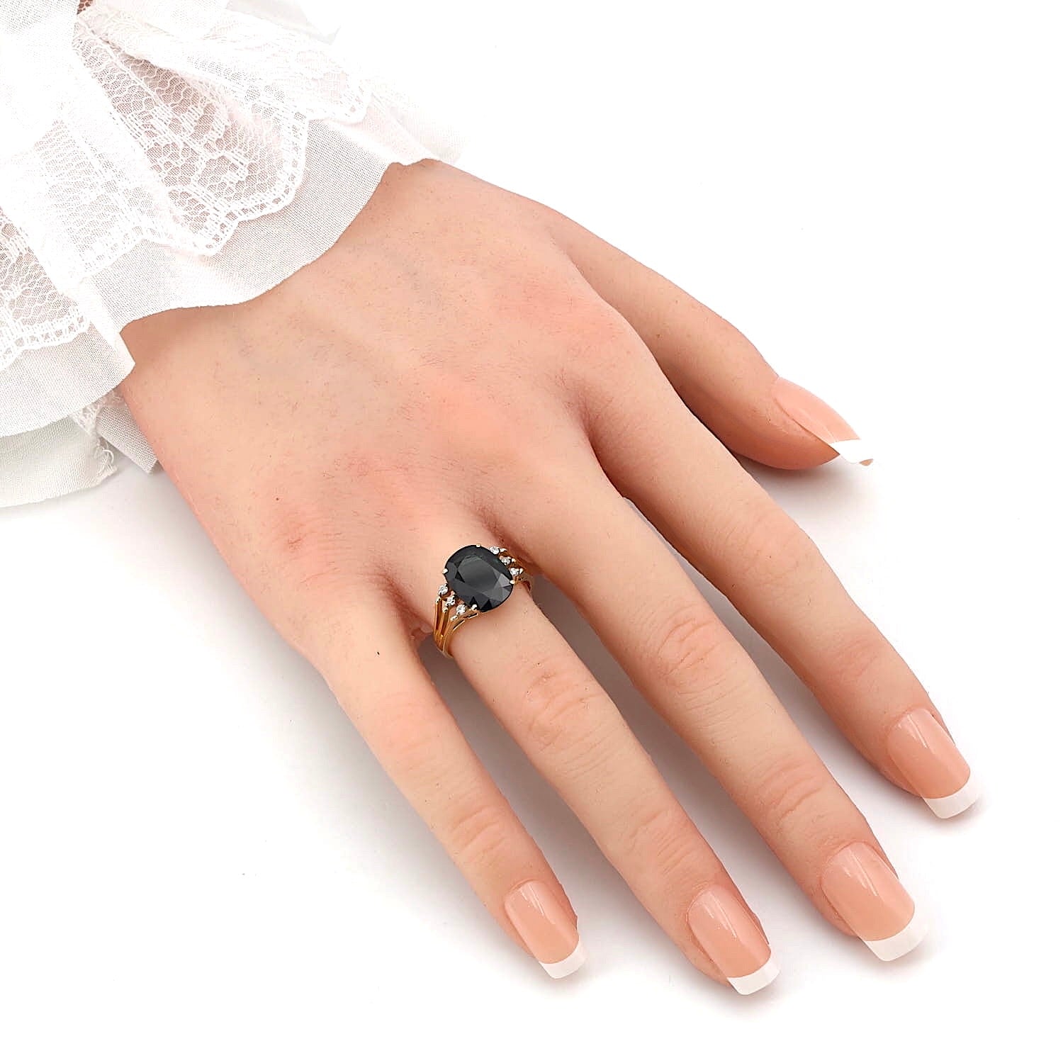 Ring in 585er Gelbgold mit einem blauen Saphir und Diamanten, an einer künstlichen Hand