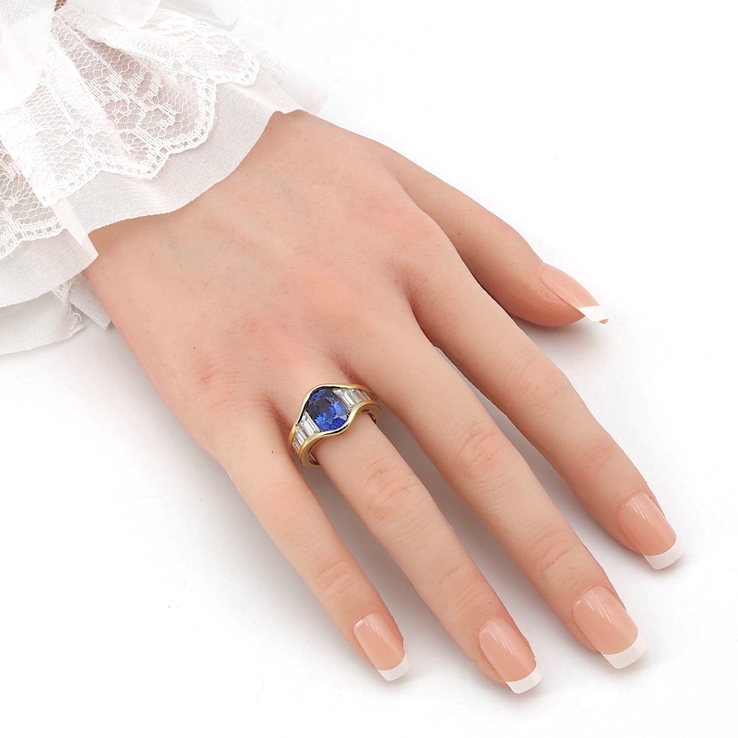 Ring in 750er Gelbgold mit einem blauen Saphir ca. 4,0 ct und insgesamt ca. 2,0 ct Diamanten, an einer künstlichen Hand