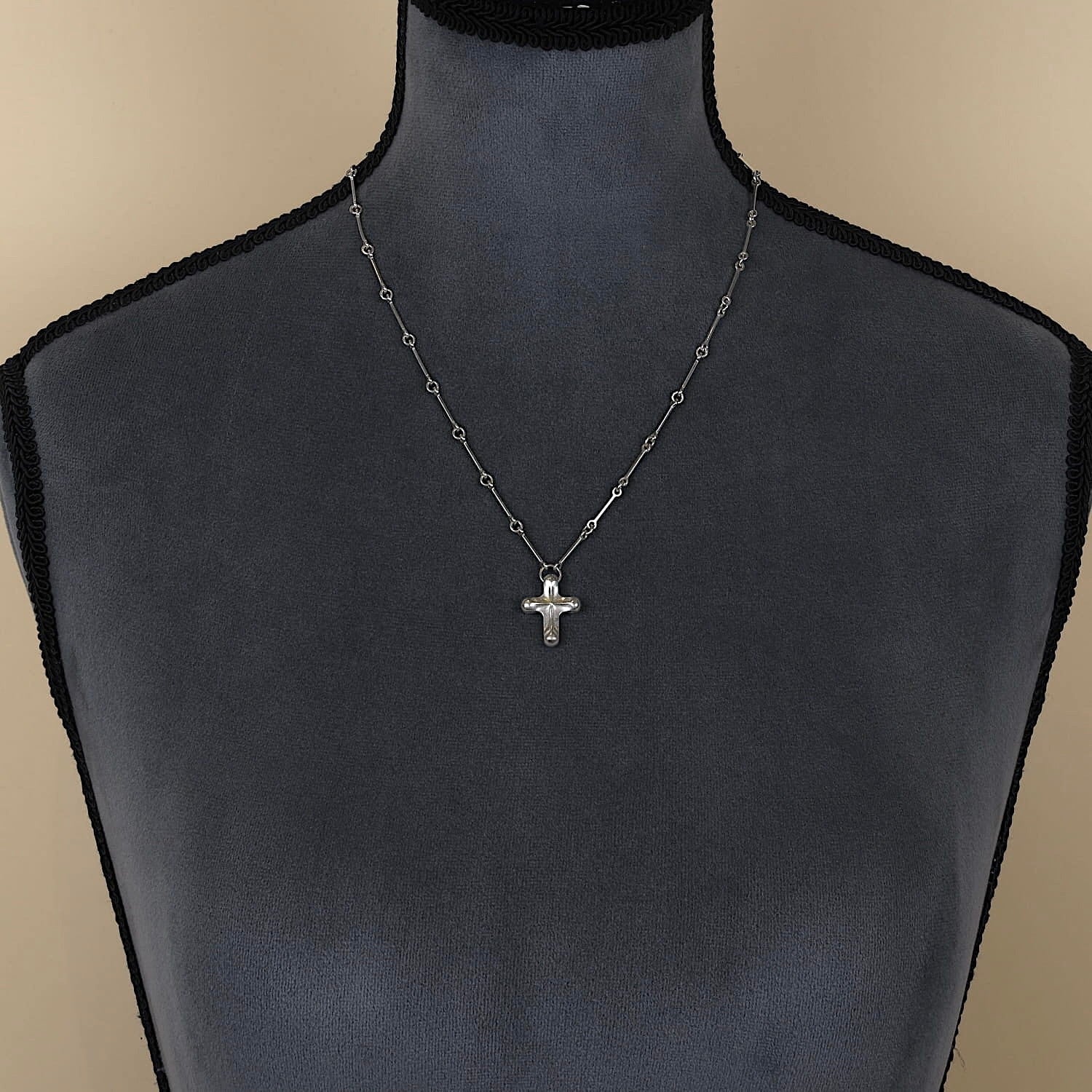 Lapponia Kette, Design Björn Weckström mit einem Kreuz in 925er Silber, an einer dunklen Büste