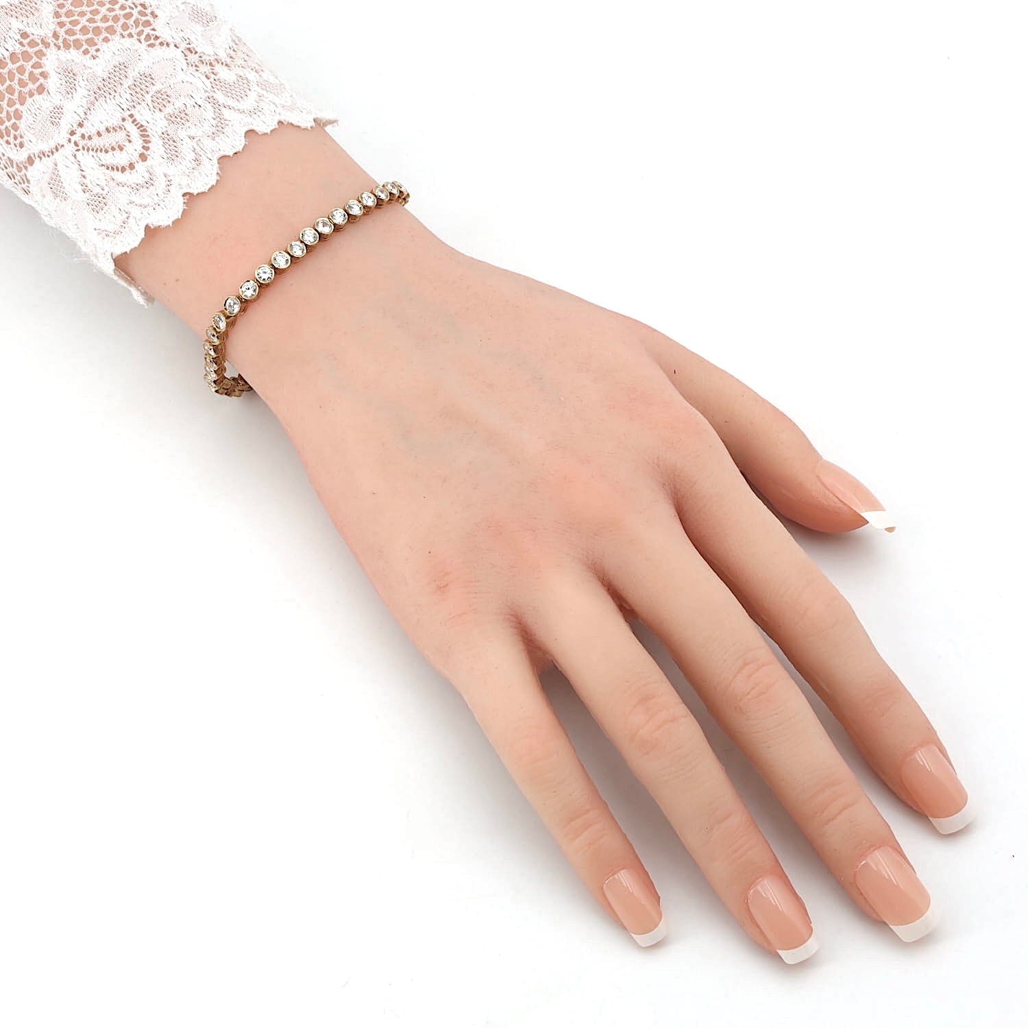 Tennisarmband in Silber, vergoldet mit Cubic Zirkonias, am Arm einer Puppe