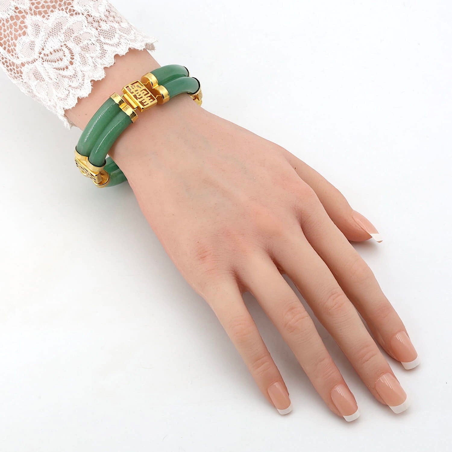 Armband aus grünem Aventurin-Quarz, vergoldet, an einem künstlichen Arm