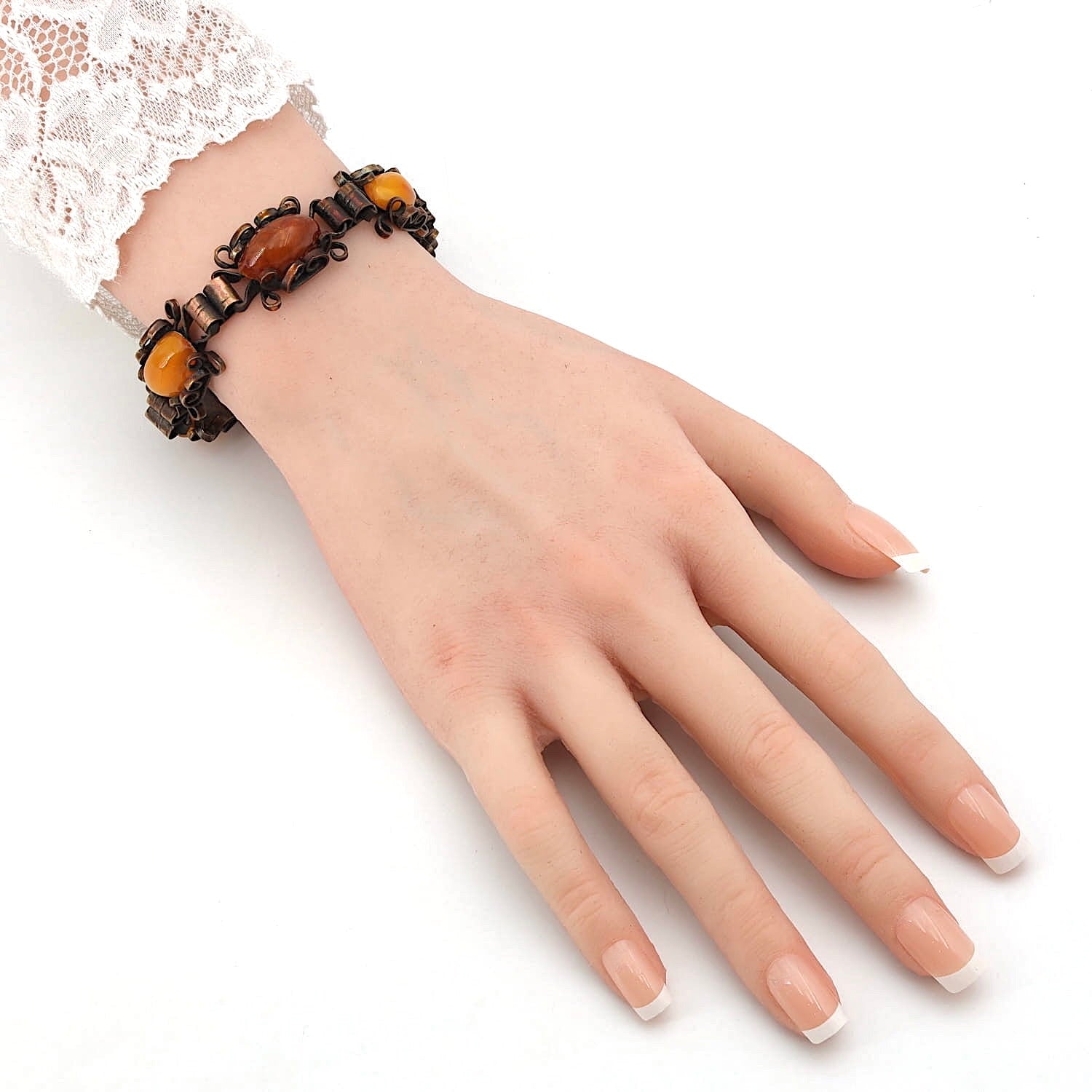 Copper bracelet with amber stones on an artificial wrist