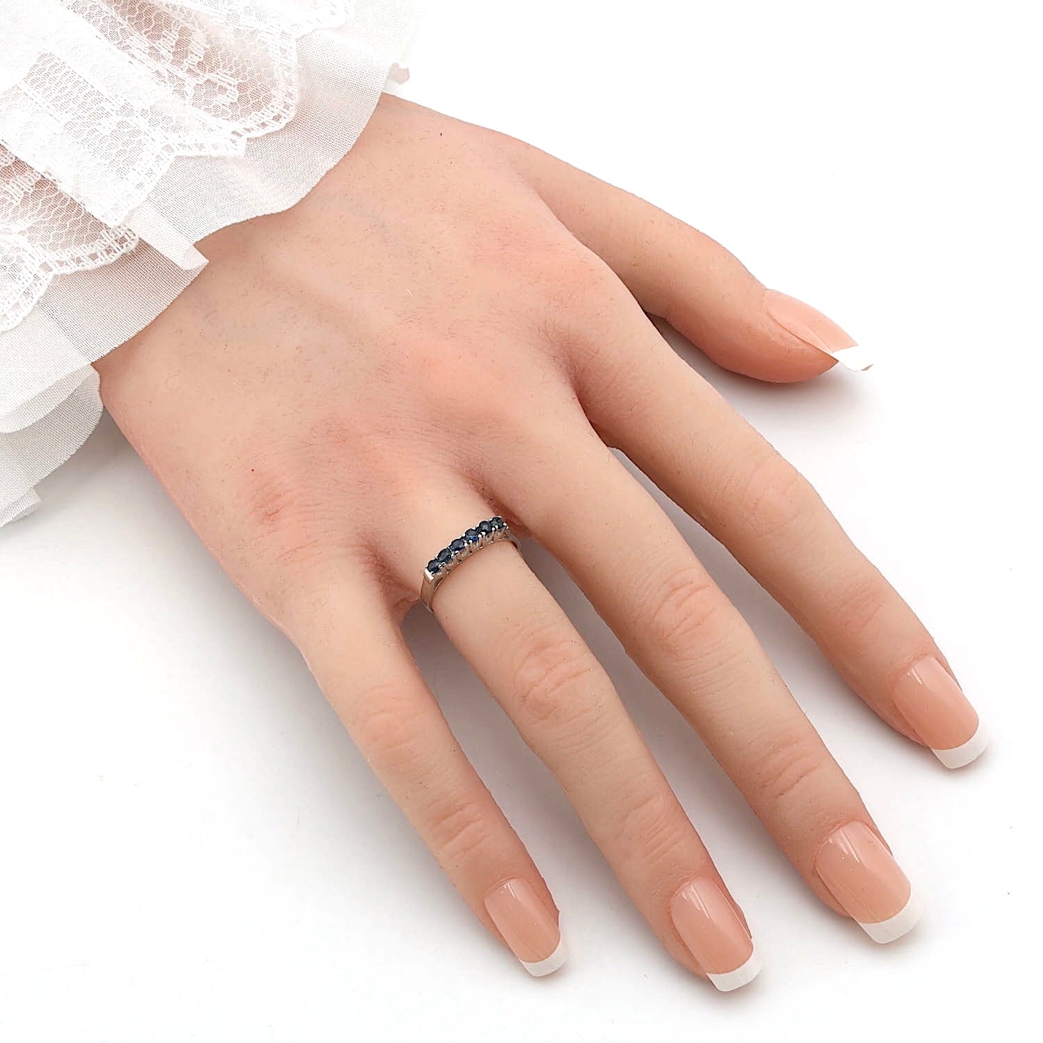 Ring in 585er Weißgold mit blauen Saphiren, an einer künstlichen Hand