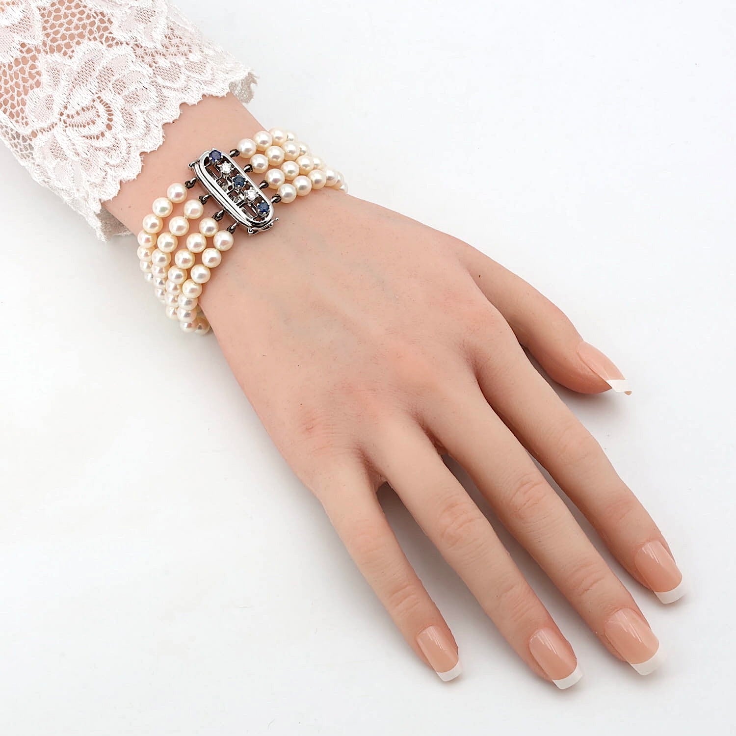 Armband aus 4 Reihen Zuchtperlen mit einem Schloß aus 585er Weißgold mit Saphiren und Brillanten, am einer künstlichen Arm