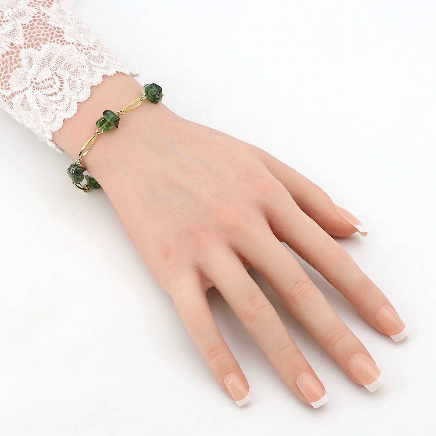 Bracelet in 333 yellow gold with green tourmaline tumbled stones, on an artificial arm