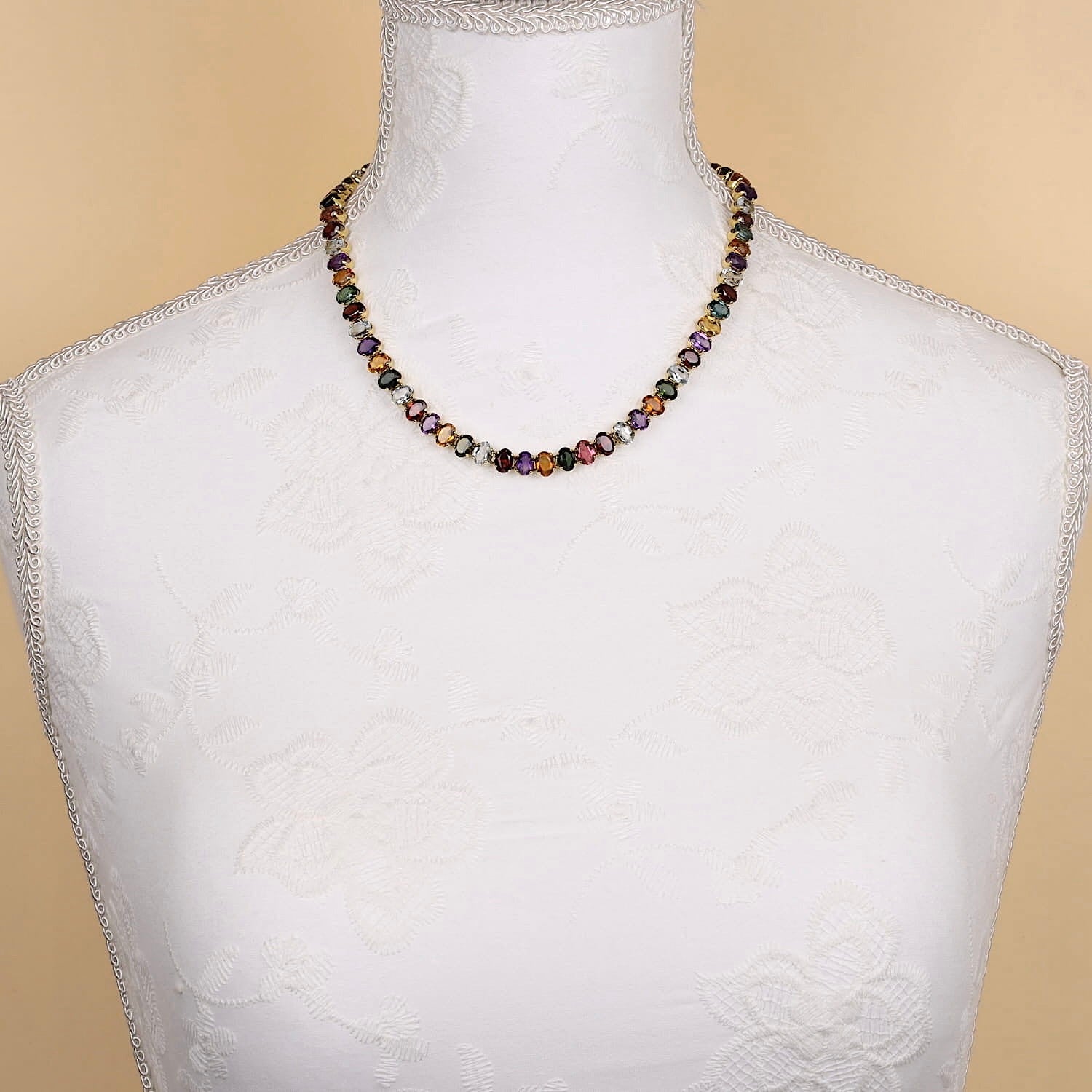 , an einer weißen BüsteKette in 750er Gelbgold mit bunten Edelsteinen aus Aquamarin, Citrin, Amethyst, Turmalin und Granat, an einer weißen Büste