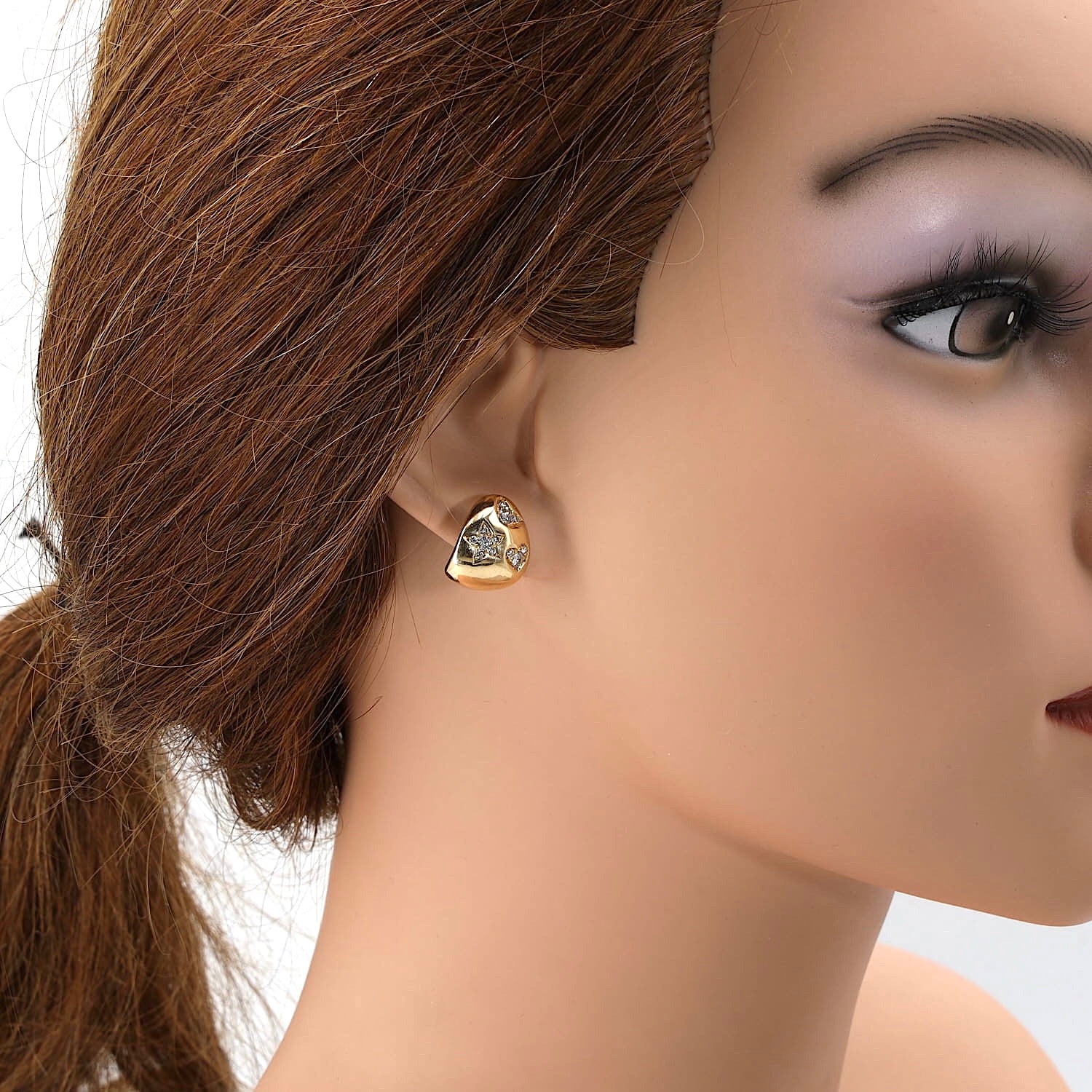 Ohrstecker in 750er Gelbgold mit Brillanten, einzelnd am Ohr einer Puppe