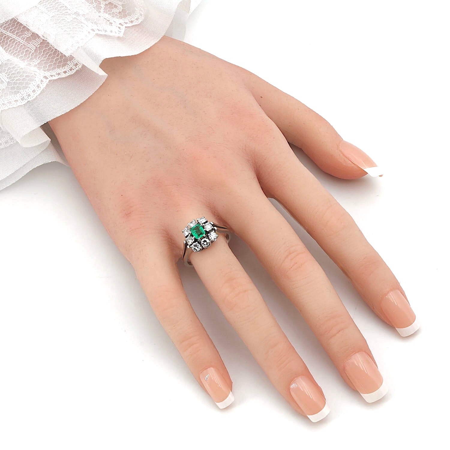 Ring in 750 white gold with an emerald and Brilliants total approx. 0.90 ct, on an artificial hand