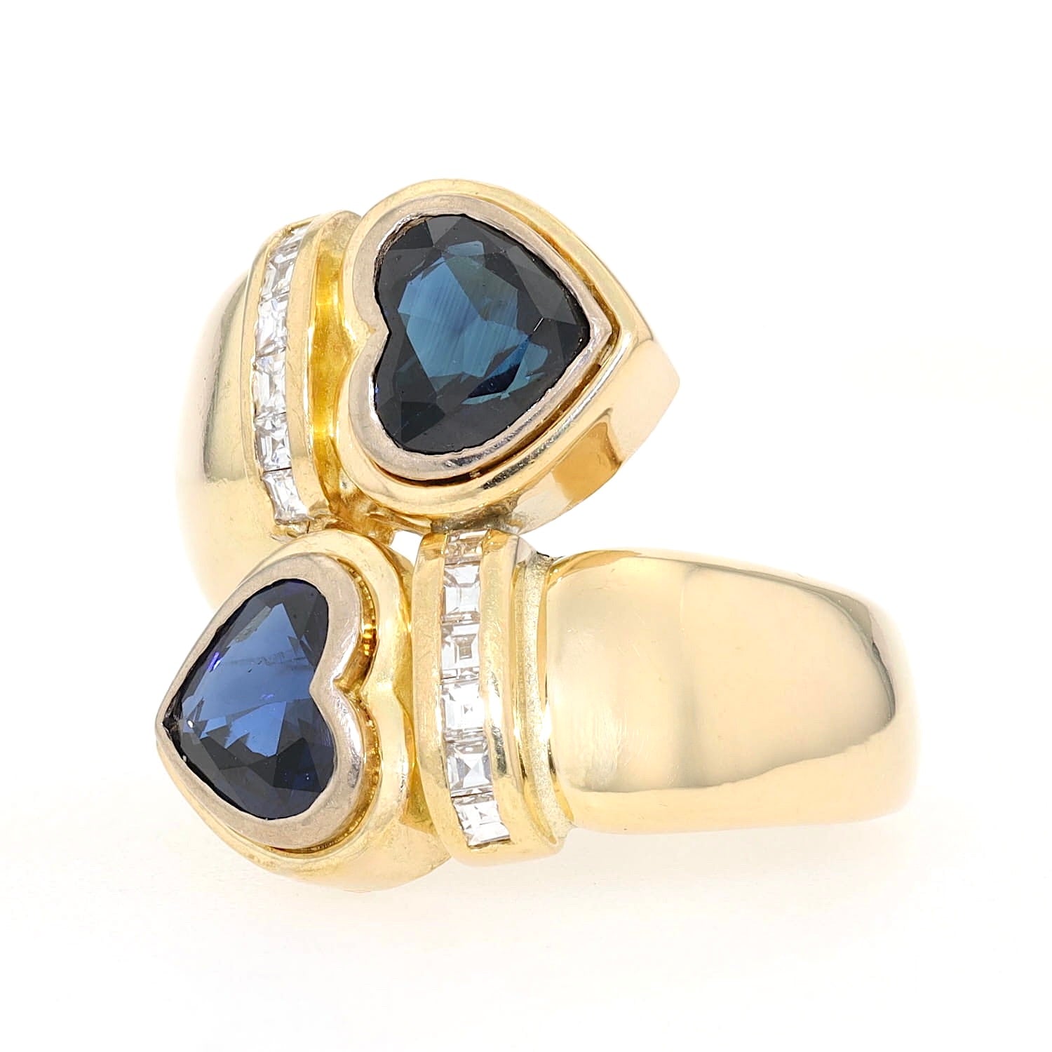 Ring in 750er Gelbgold mit zwei blauen Saphiren in Herzform und Diamanten, liegend frontal von vorne links gedreht
