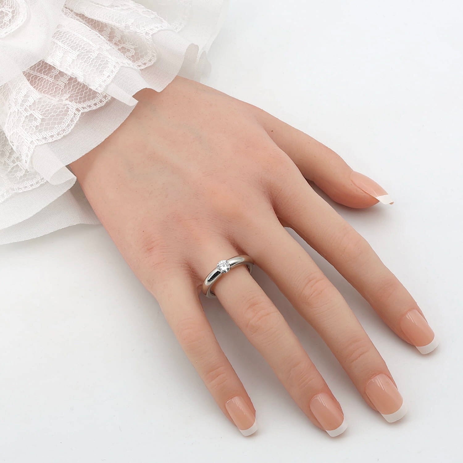 Niessing Spannring in 950er Platin mit einem Brillanten, ca. 0,50 ct , an einer künstlichen Hand