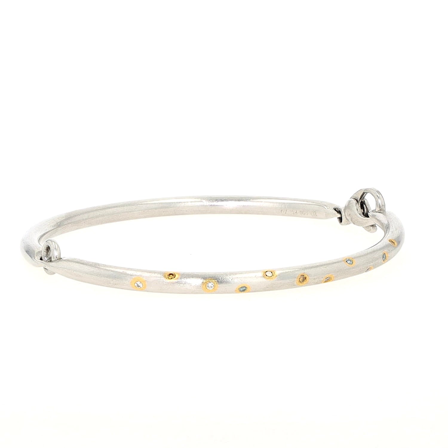 Henrich & Denzel Armreif in 950er Paltin mit weißen und farbigen Diamanten, liegend frontal leicht rechts gedreht