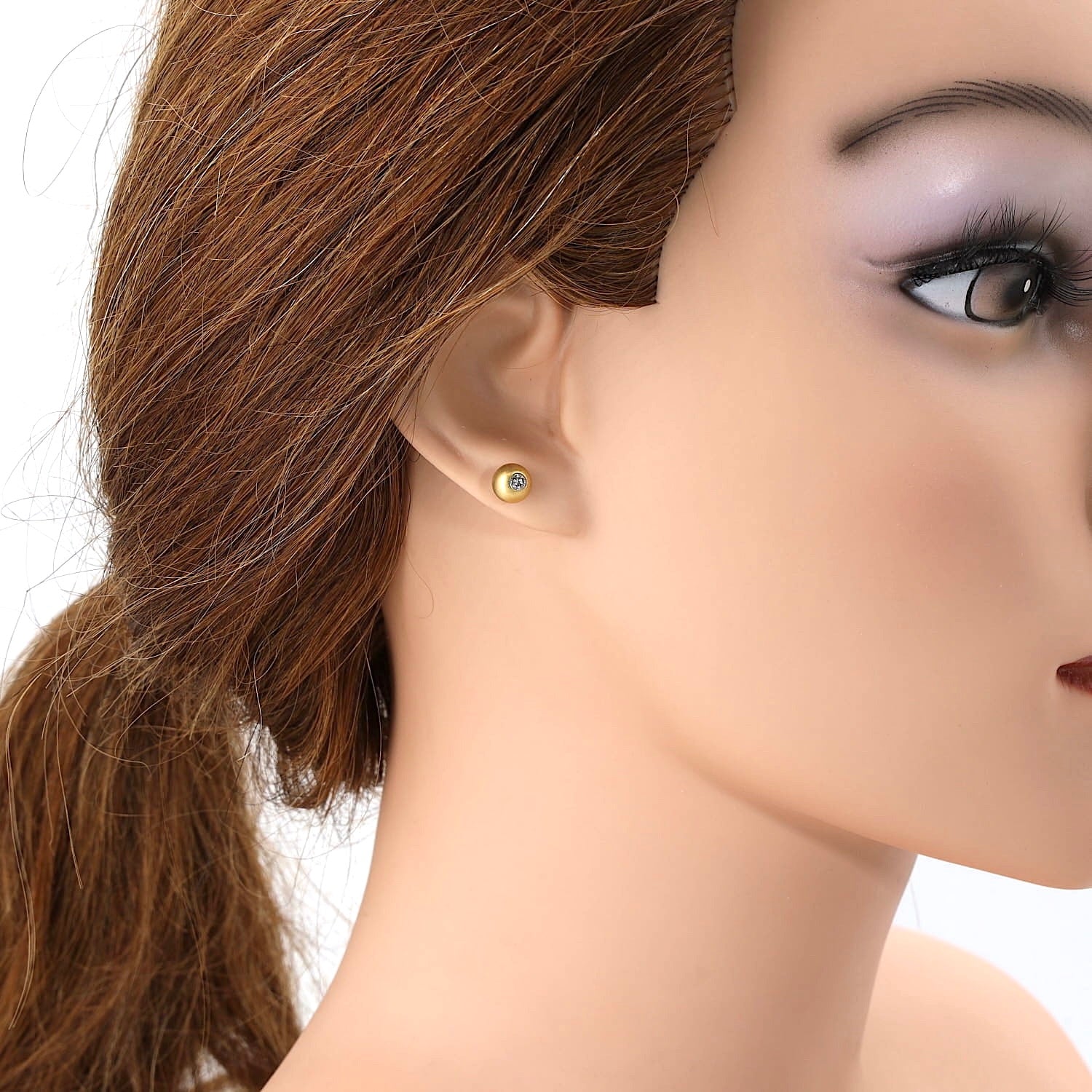 Ohrstecker in 750er Gelbgold mit je einem Brillanten, am Ohr einer Puppe