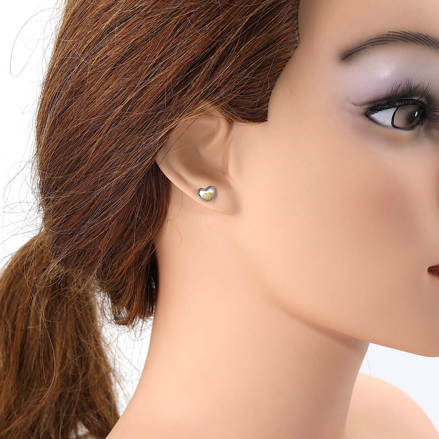 Henrich & Denzel Ohrstecker in 950er Platin mit Goldauflage, am Ohr einer Puppe