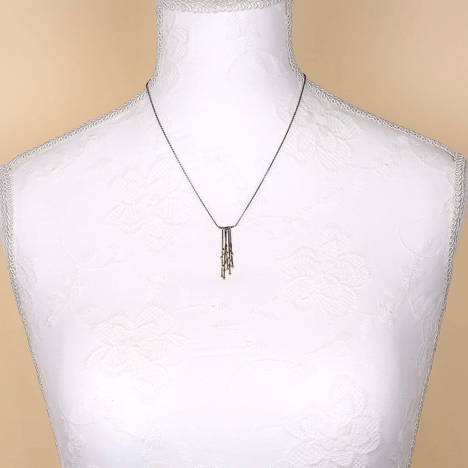 Collier aus 950er Platin mit Elementen aus 750er Gelbgold, an einer weißen Büste