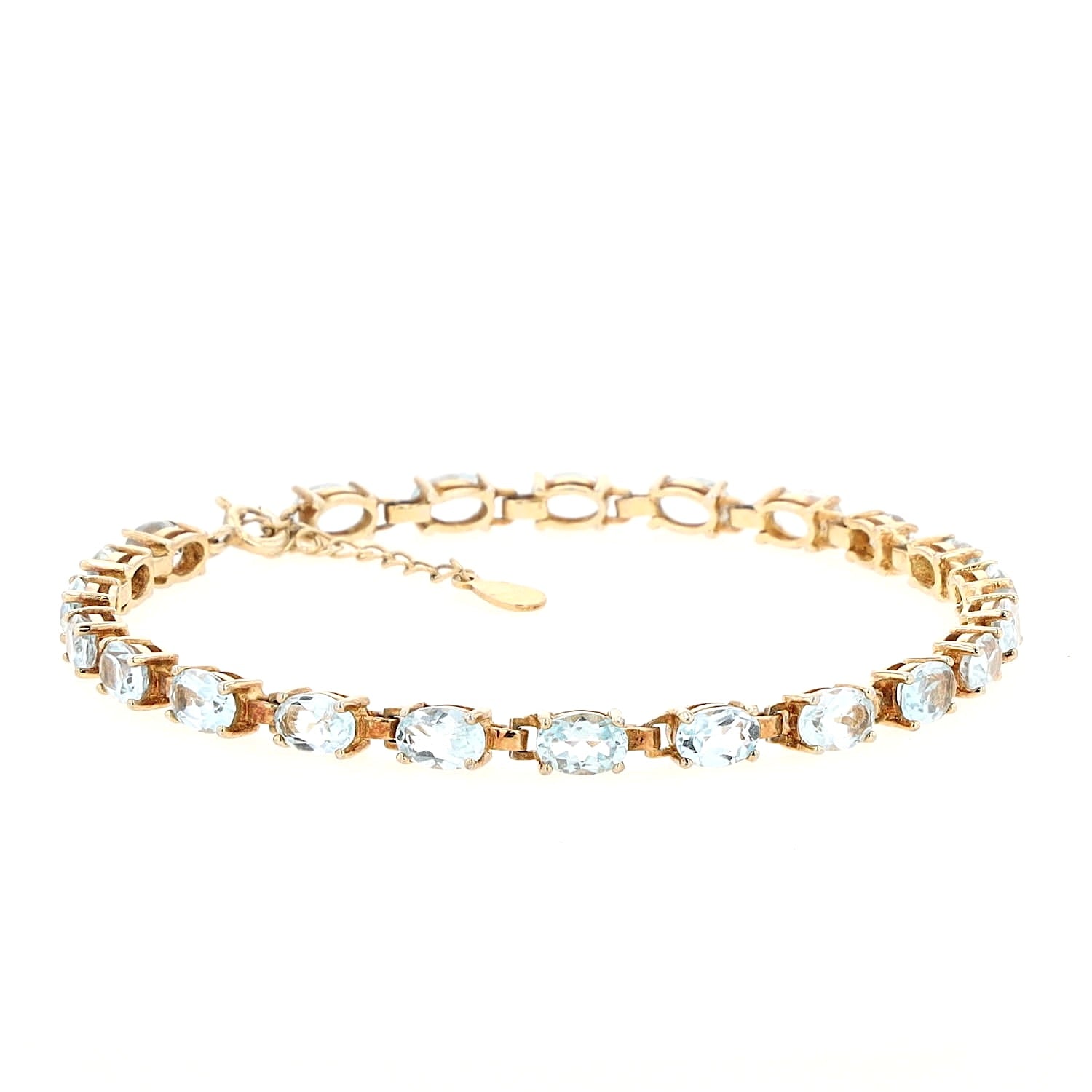 Bracelet made of gold-plated 925 silver with blue topazes, lying closed and turned to the right