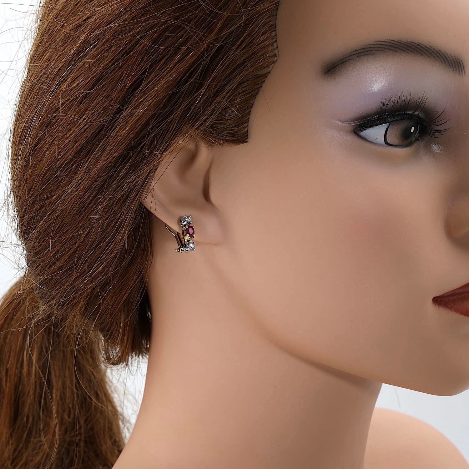 Paar Ohrclip in 585er Bicolor Gold mit je einem Rubin und Brillanten, an einer Puppe