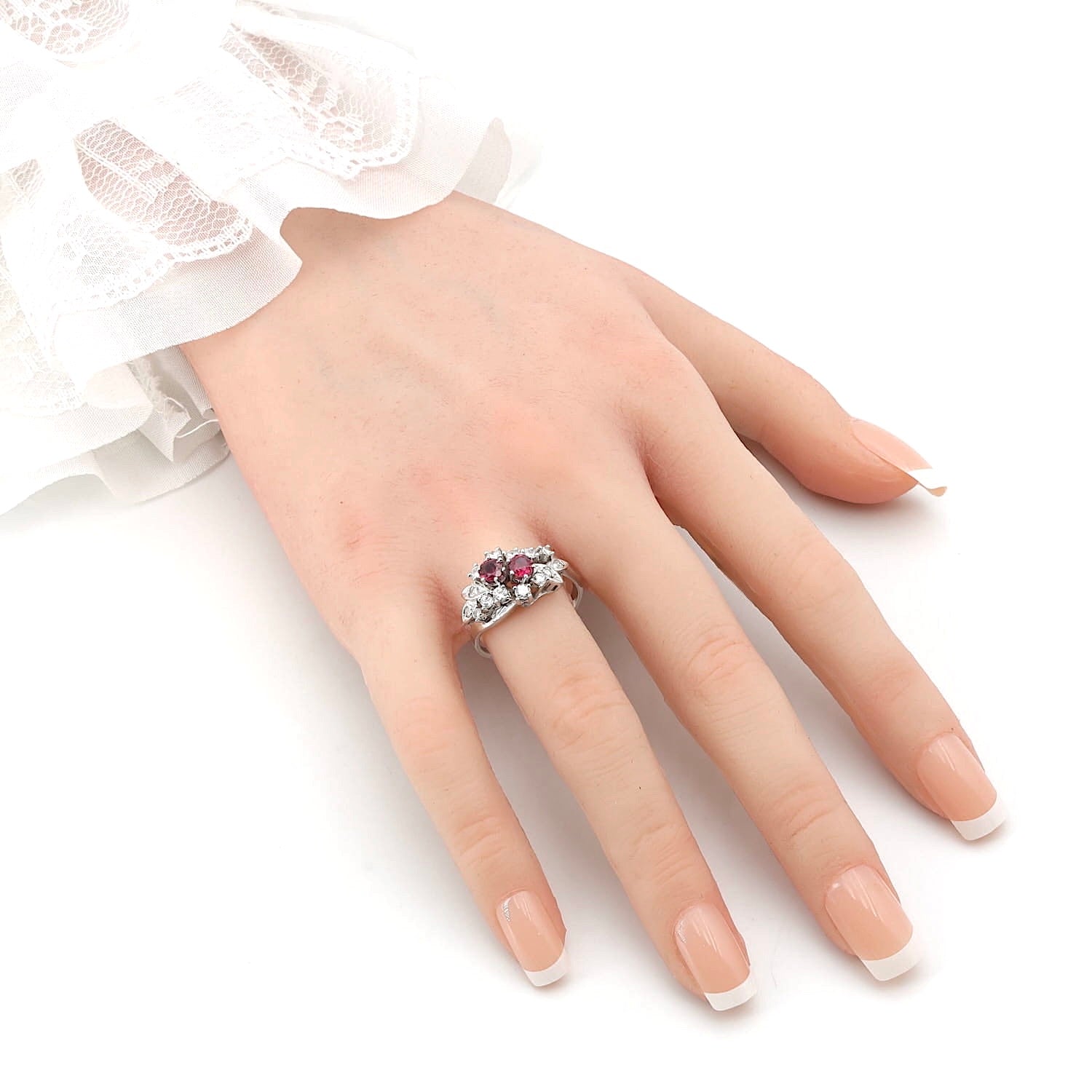 Cluster ring around 1970 in 585 white gold with rubies and diamonds, on an artificial hand