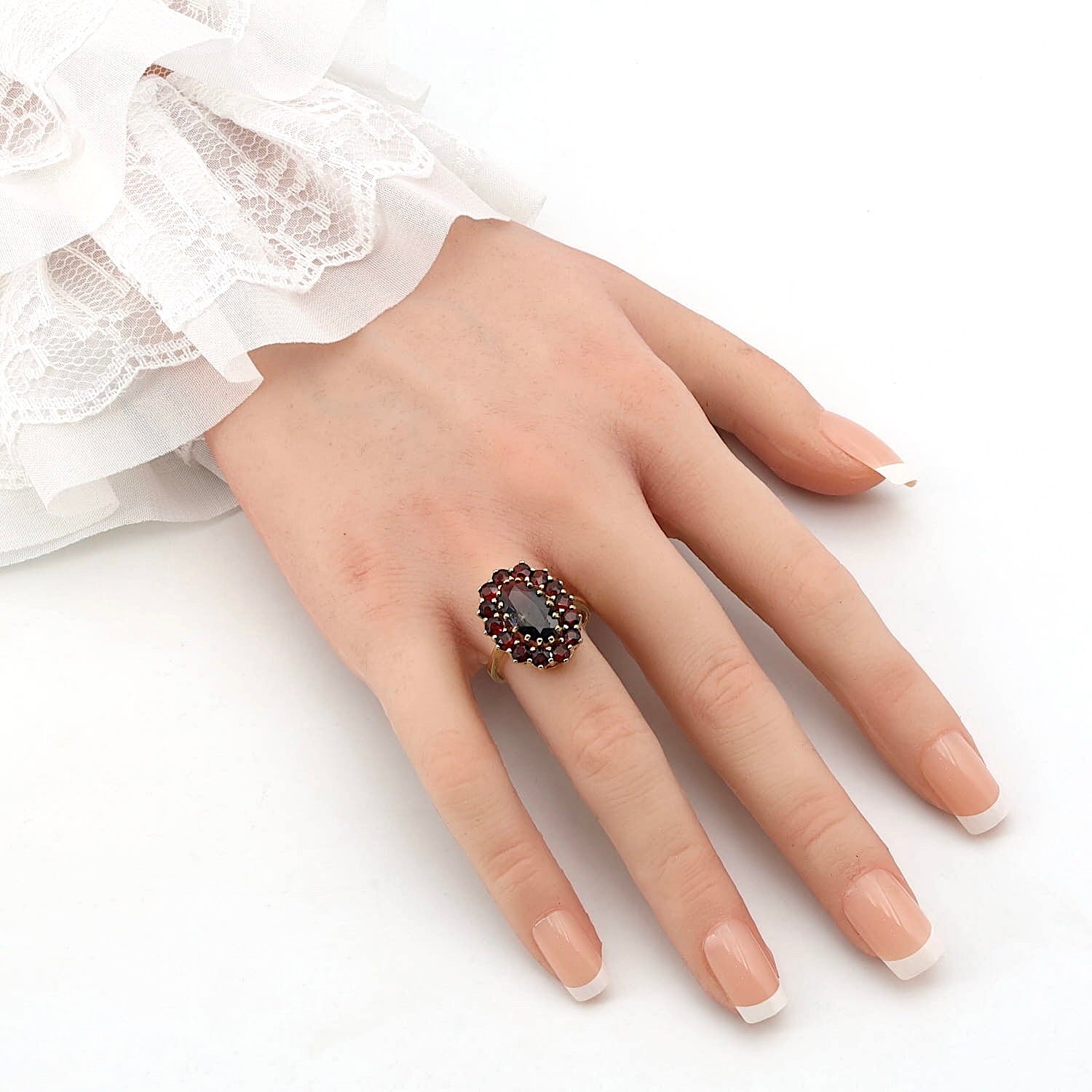 Garnet ring in 333 yellow gold, on an artificial hand