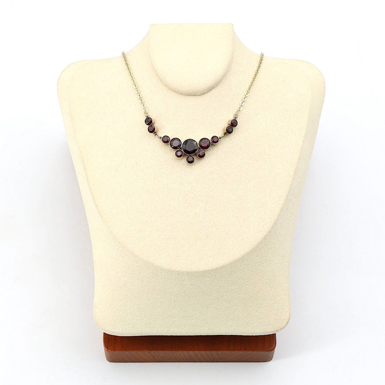 Granatcollier in 333er Gelbgold, an einer kleinen hellen Büste