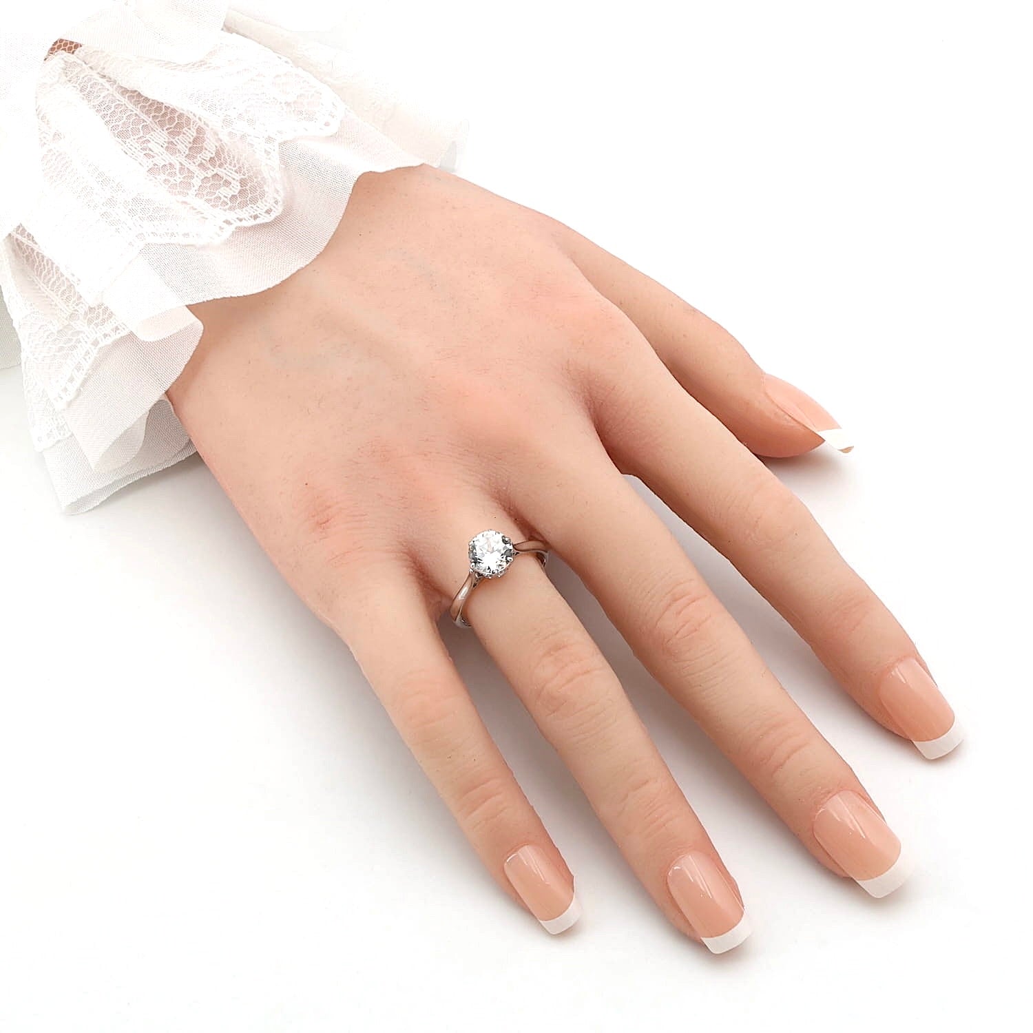 Ring in 18kt white gold with a white natural zircon, on an artificial hand
