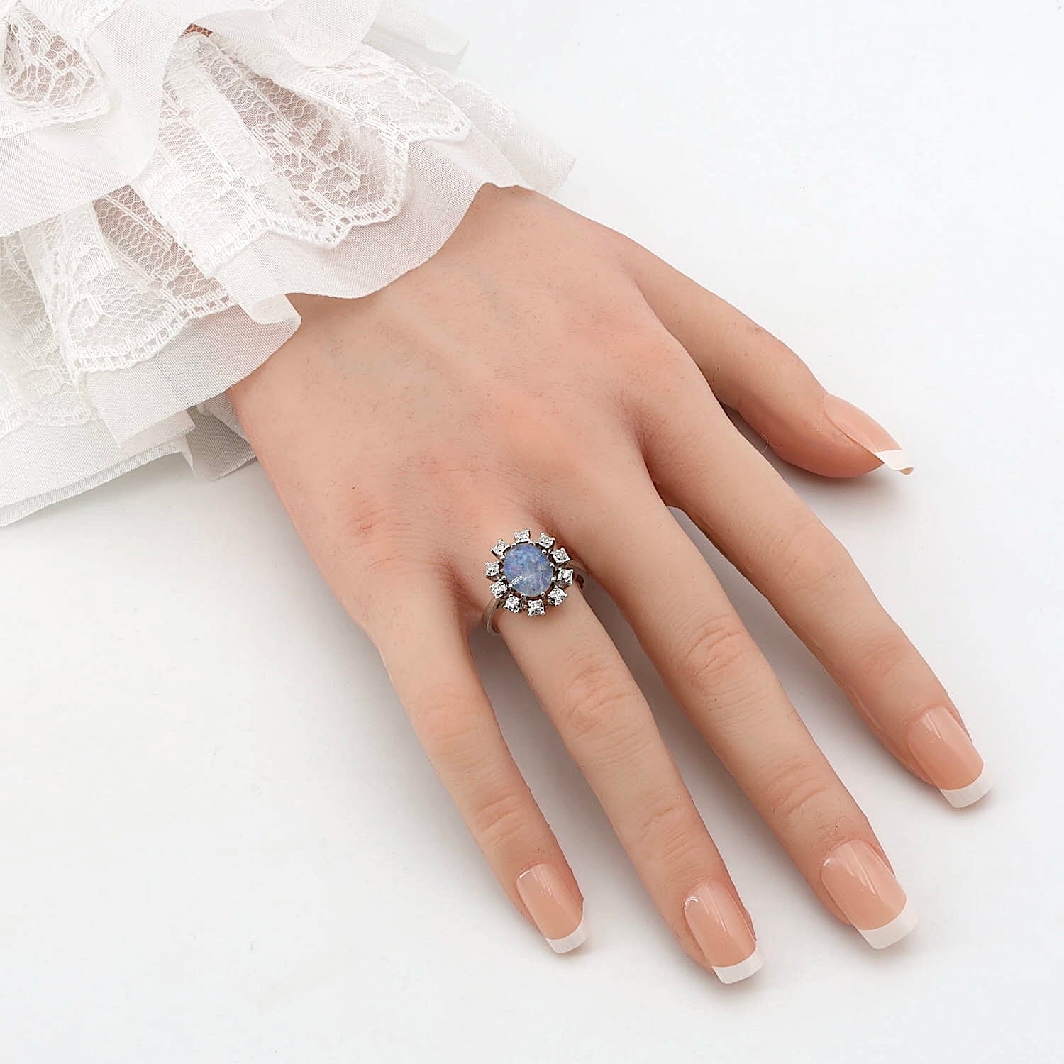 Ring in 585 white gold with an opal triplet and diamonds, on an artificial hand