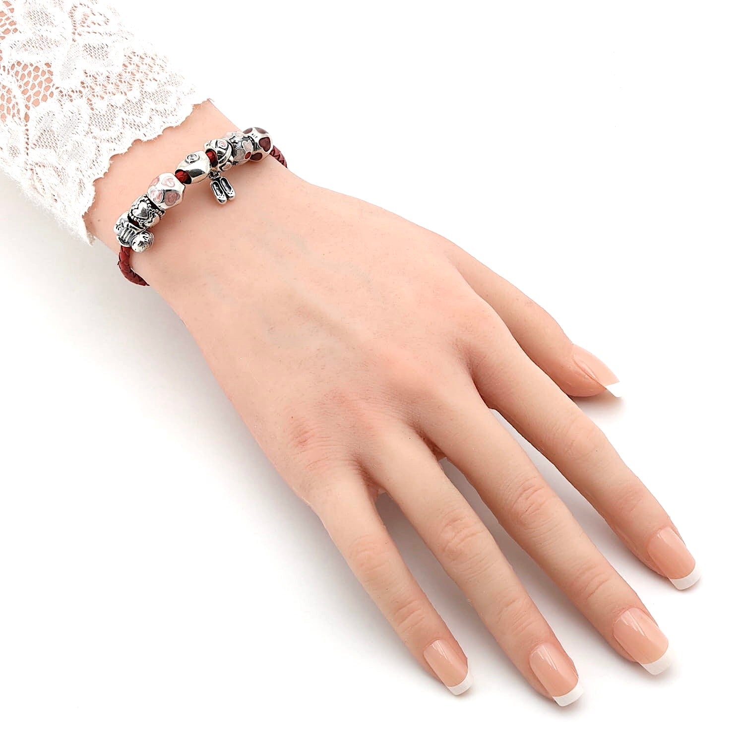 Rotes Lederarmband mit 8 Charms von Pandora, an einem künstlichen Arm
