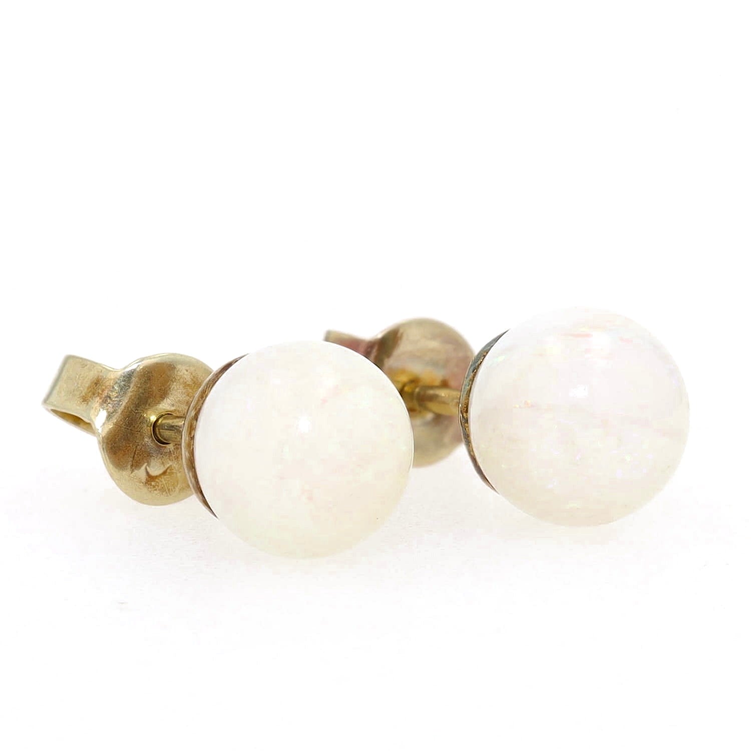 Pair of stud earrings in 585 yellow gold, each with a white opal ball, turned to the right