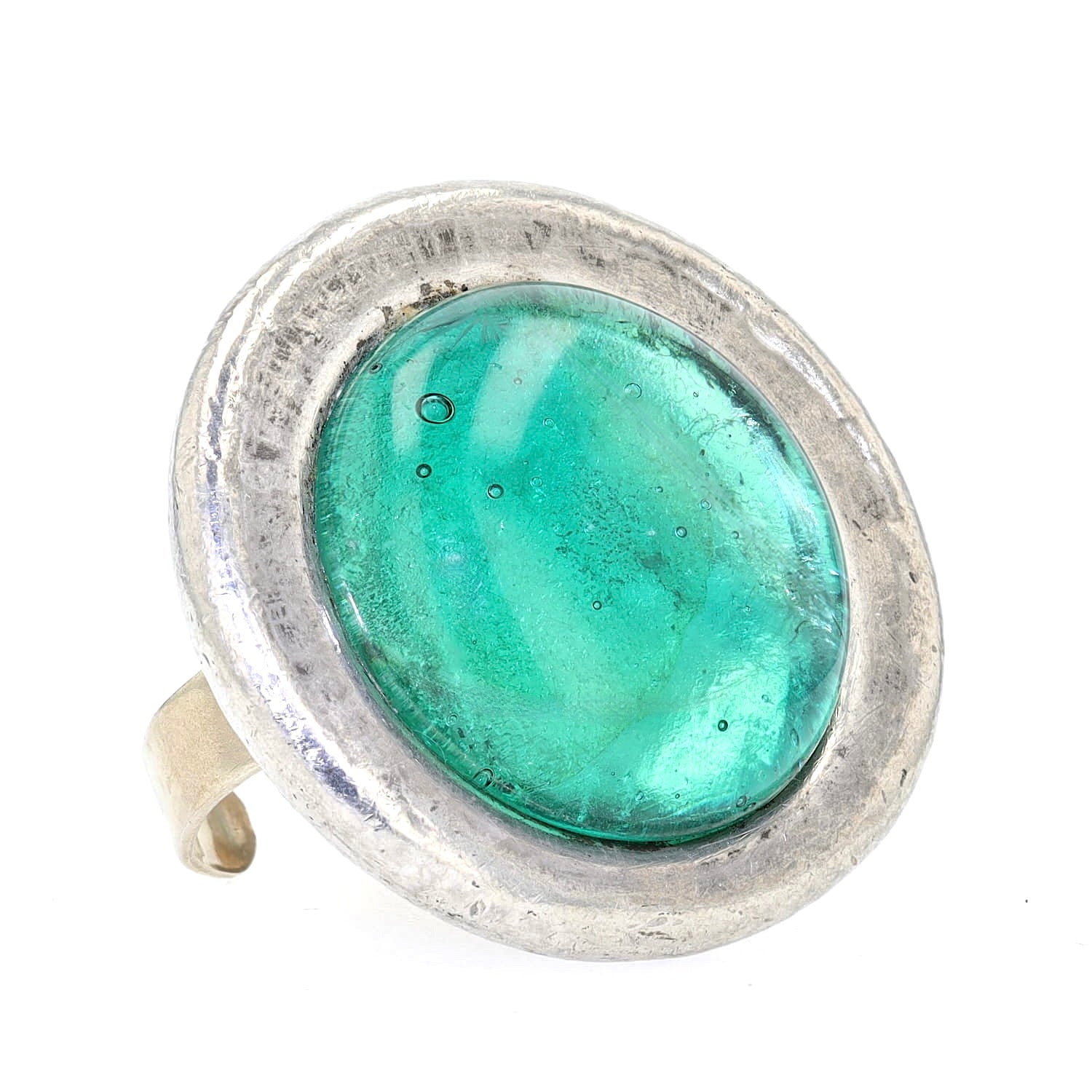 Statement ring made of pewter with a green glass stone, lying slightly to the left