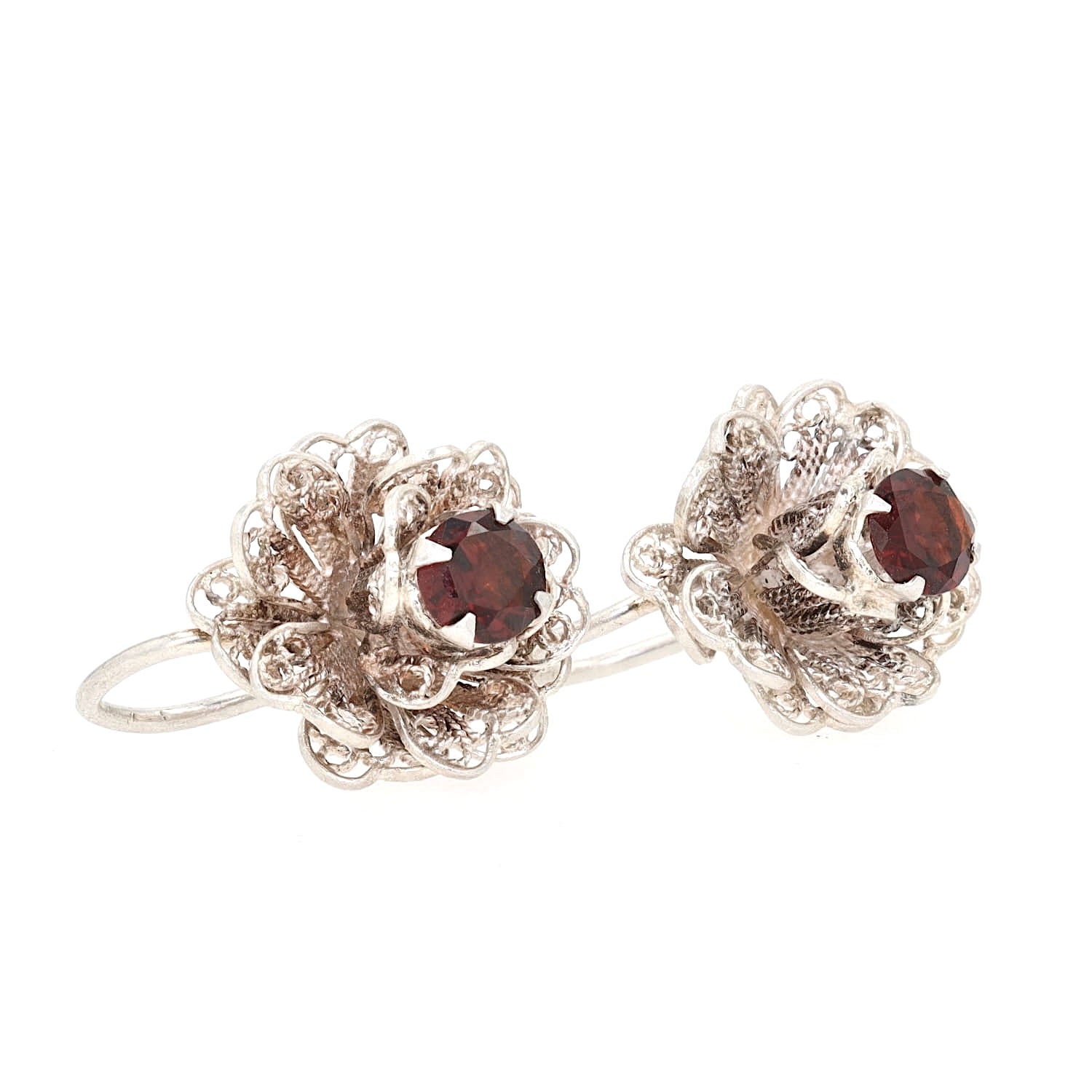 Flower-shaped earrings made of 950 silver, each with a garnet, turned to the right