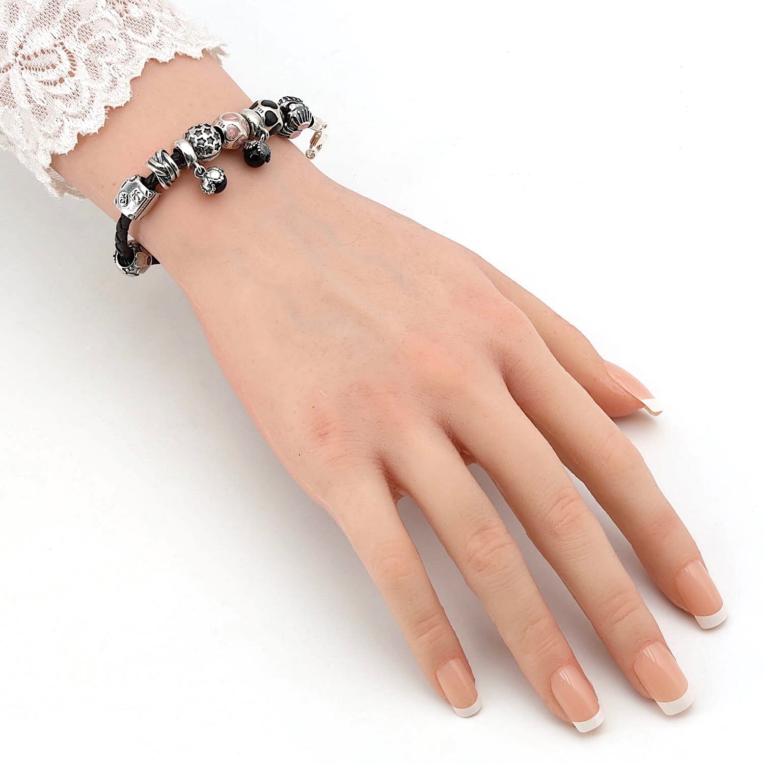Lederarmband mit 9 Charms von Pandora in 925er Silber, an einem künstlichen Arm