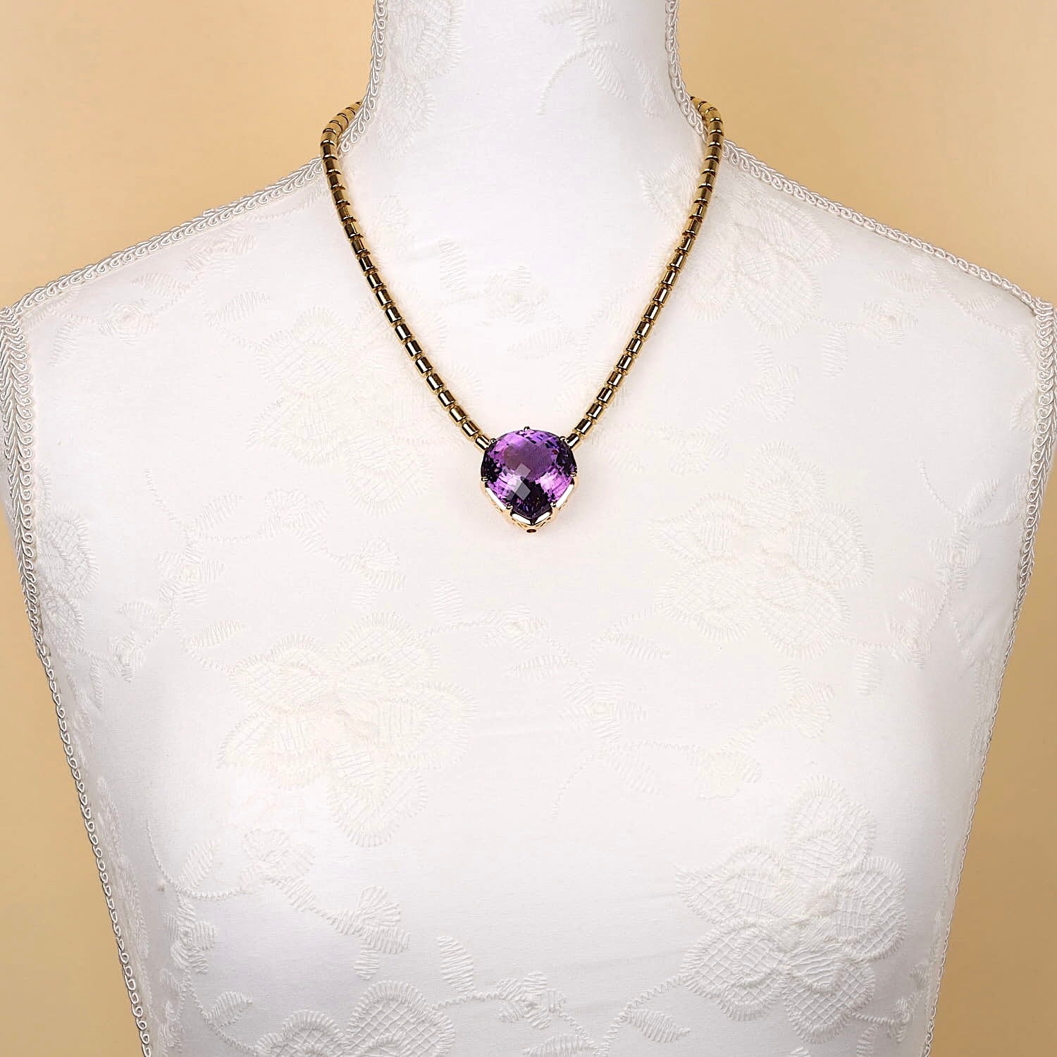 Kette Possession von Piaget mit Brillanten, Anhänger von Wempe mit einem Amethyst ca. 74 ct in 750er Gold, an einer weißen Büste