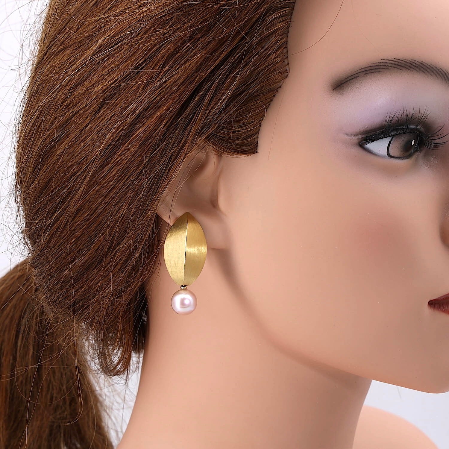 Ohrclips in 750er Gelbgold mit je einer Zuchtperle, am Ohr einer Puppe