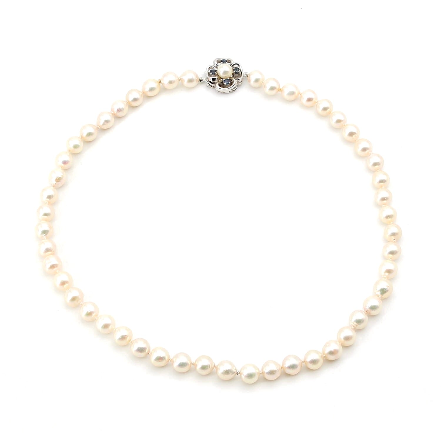 Cultured pearl necklace with a lock made of 585 white gold with a cultured pearl and blue sapphires, lying closed